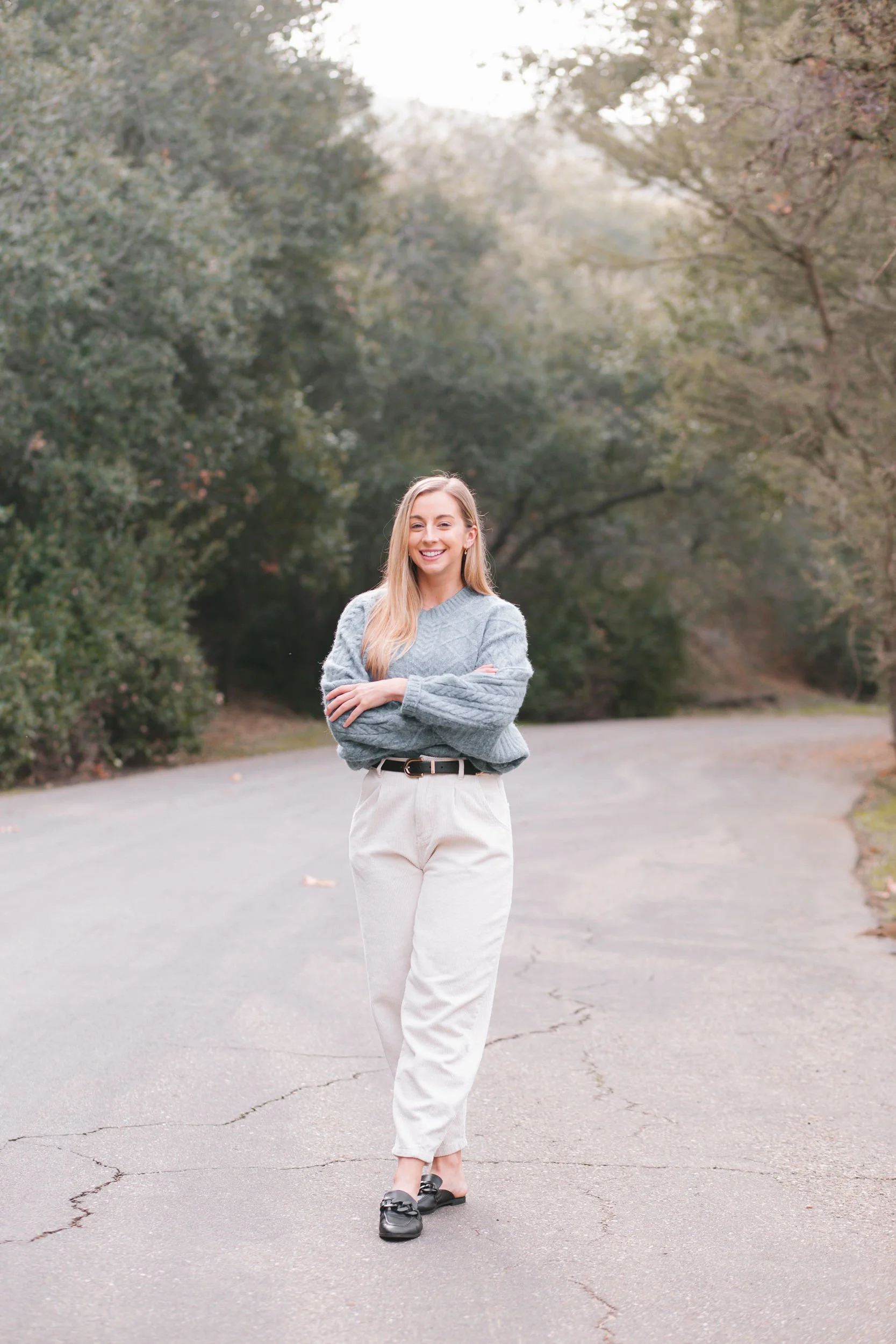 Dr. Allea stands on a wooded road in a professional headshot.