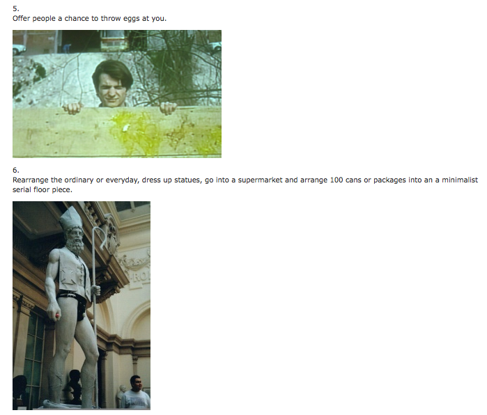 A person holding a cardboard box with a yellow paint mark, standing behind a wooden barrier, outdoors with trees and a building in the background.