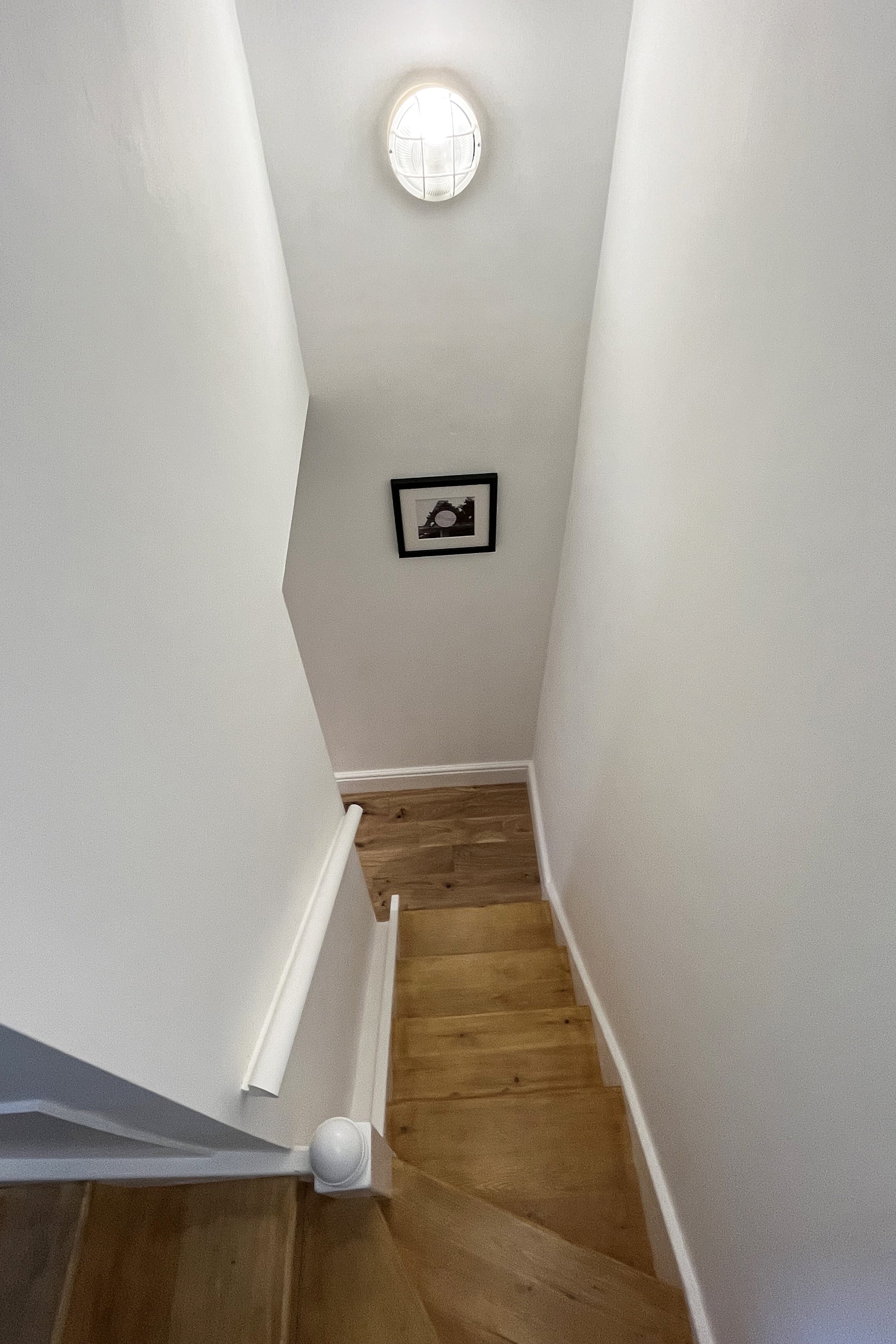 Stairs leading from the main room down to the kitchen and bathroom