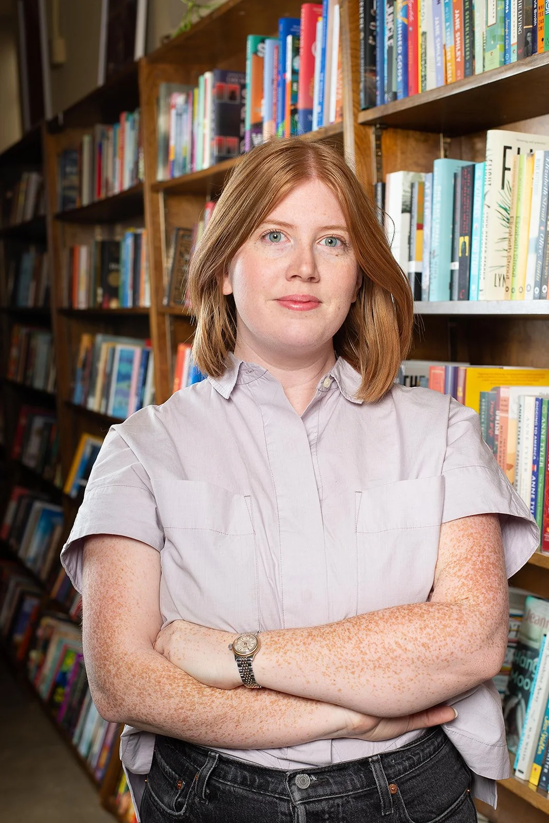 A woman in front of bookshelves