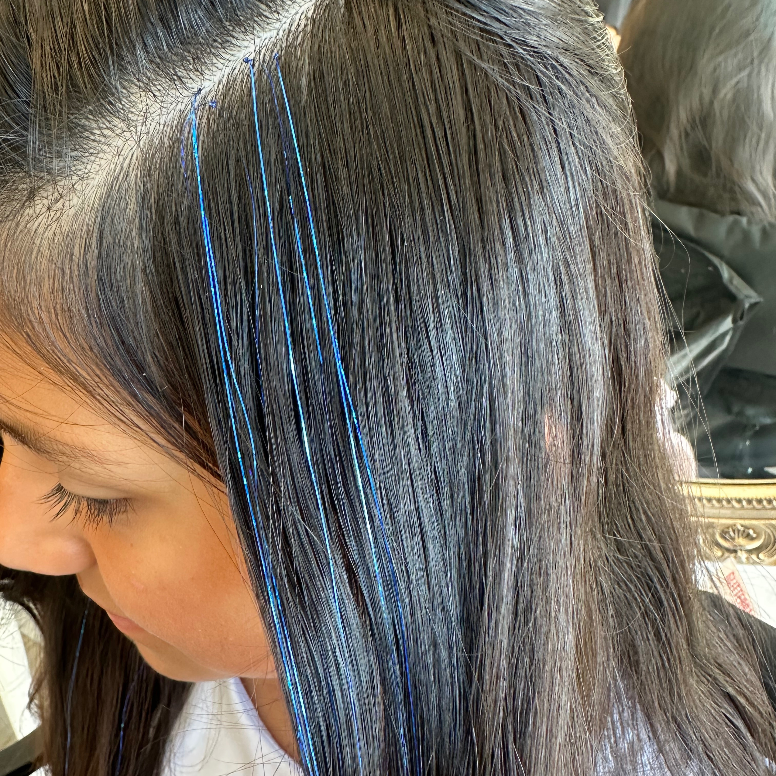 Blue hair tinsel professionally installed for long-lasting sparkle at events.