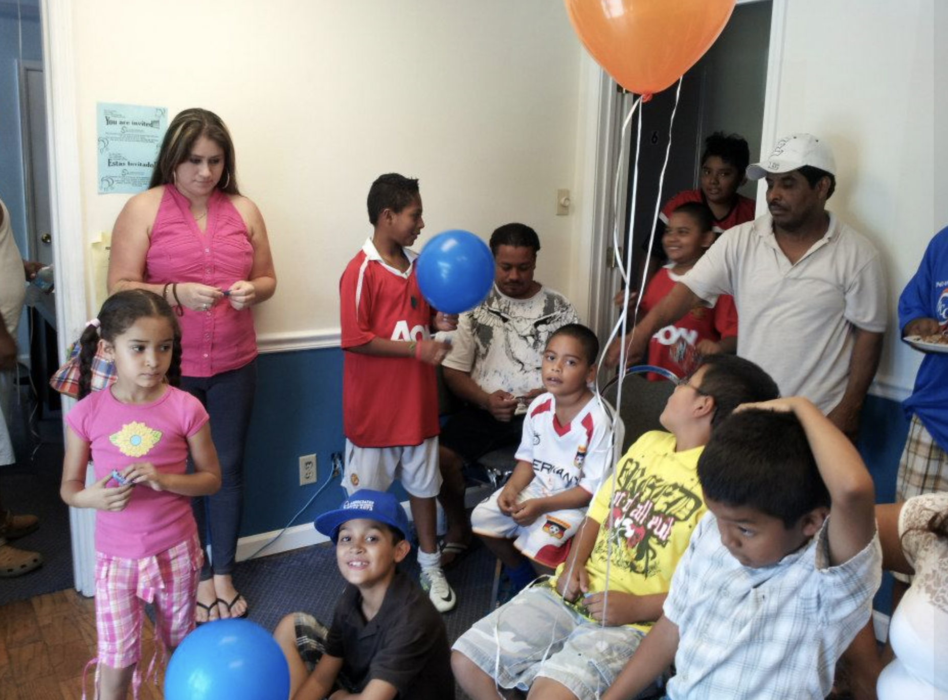 Group of children and adults at a party with balloons