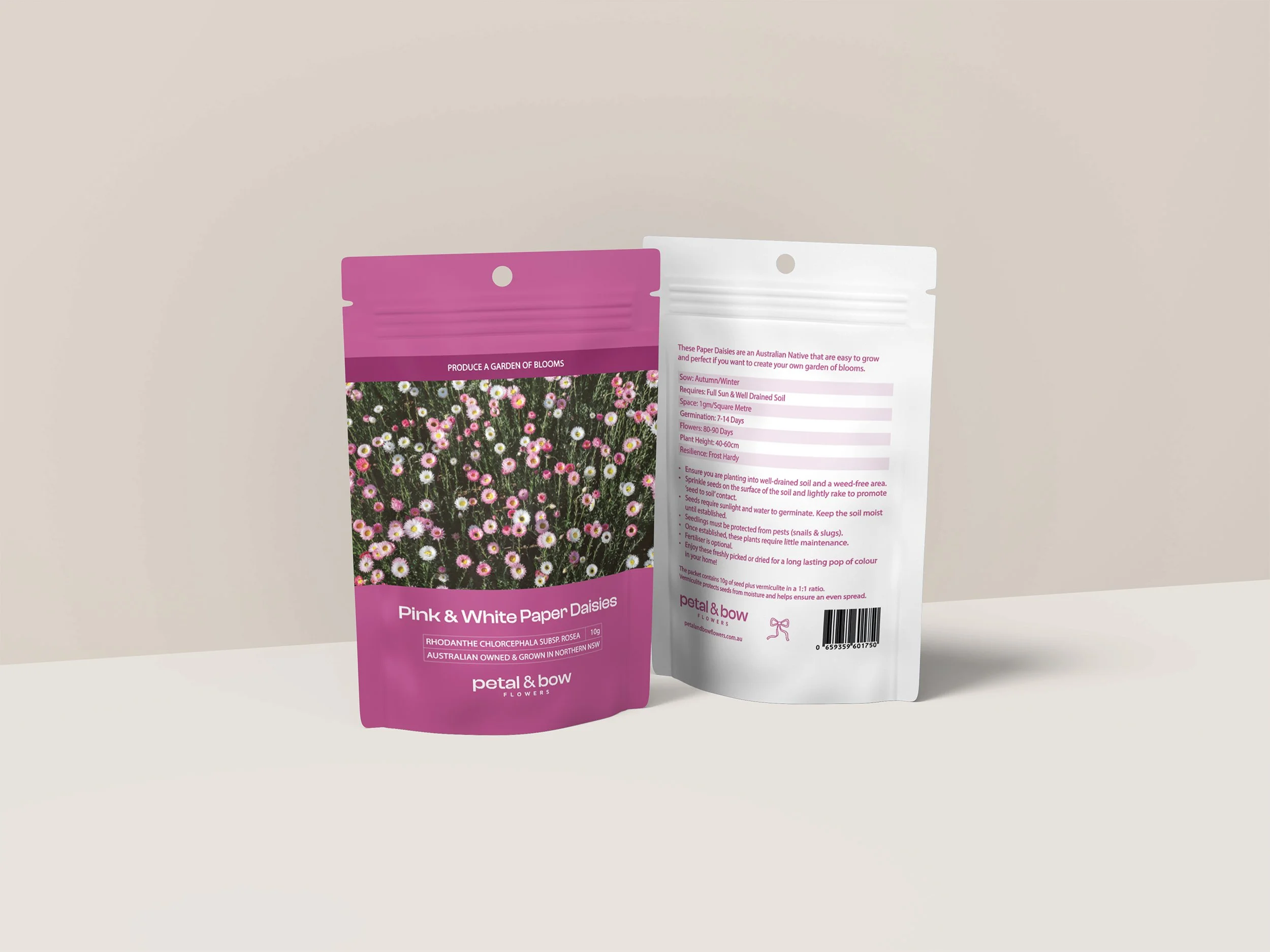 Two seed packets, one pink and one white, featuring images of daisies, placed on a neutral background.