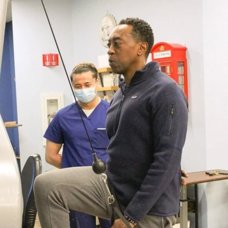 Man working out with physical therapist aid