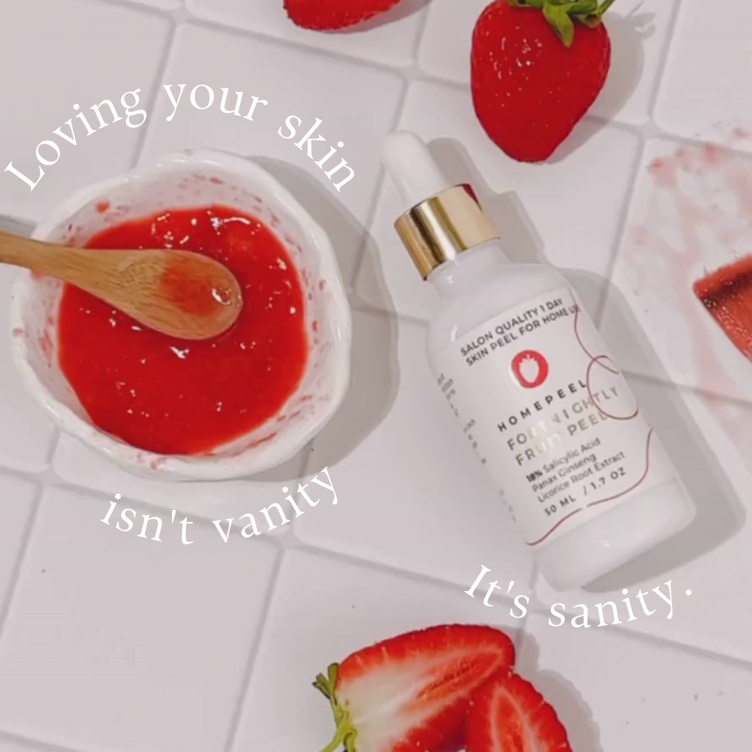 Skincare product scene with text "Loving your skin isn't vanity. It's sanity." featuring a white bottle labeled "Homepeel Fortightly Fruit Peel," a small bowl with red paste and wooden spoon, and strawberry slices on white tiled surface.
