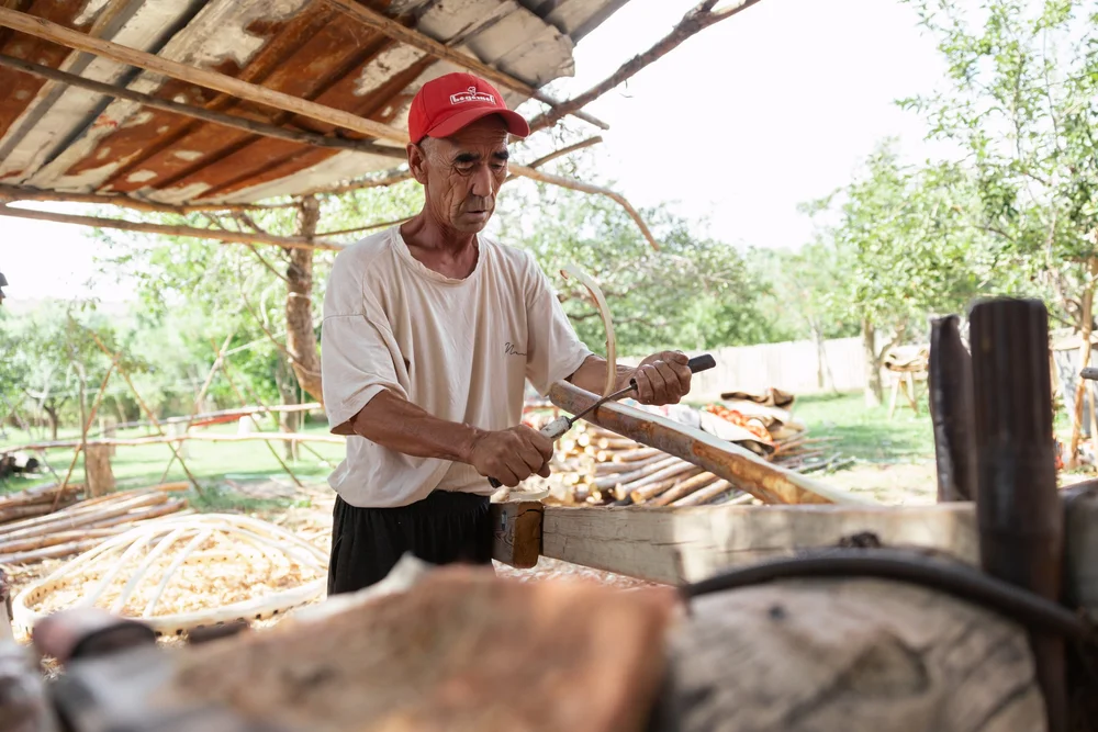 Teaching us how to peel the wood before colouring.