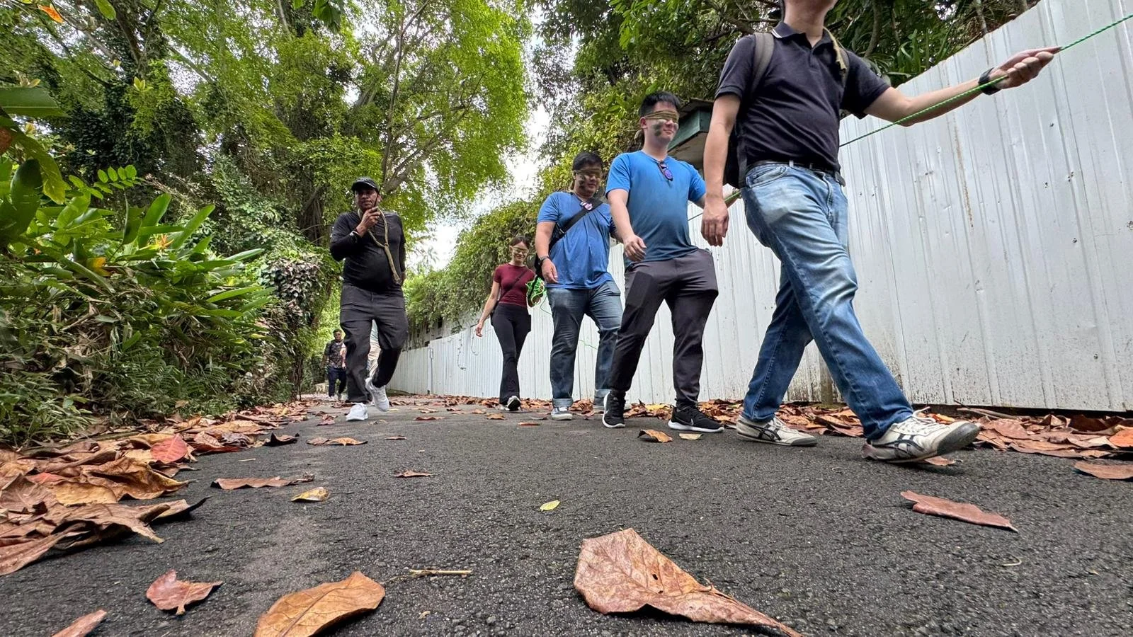 GIC corporate team members gathered along a forest road during their Fort Serapong team bonding day