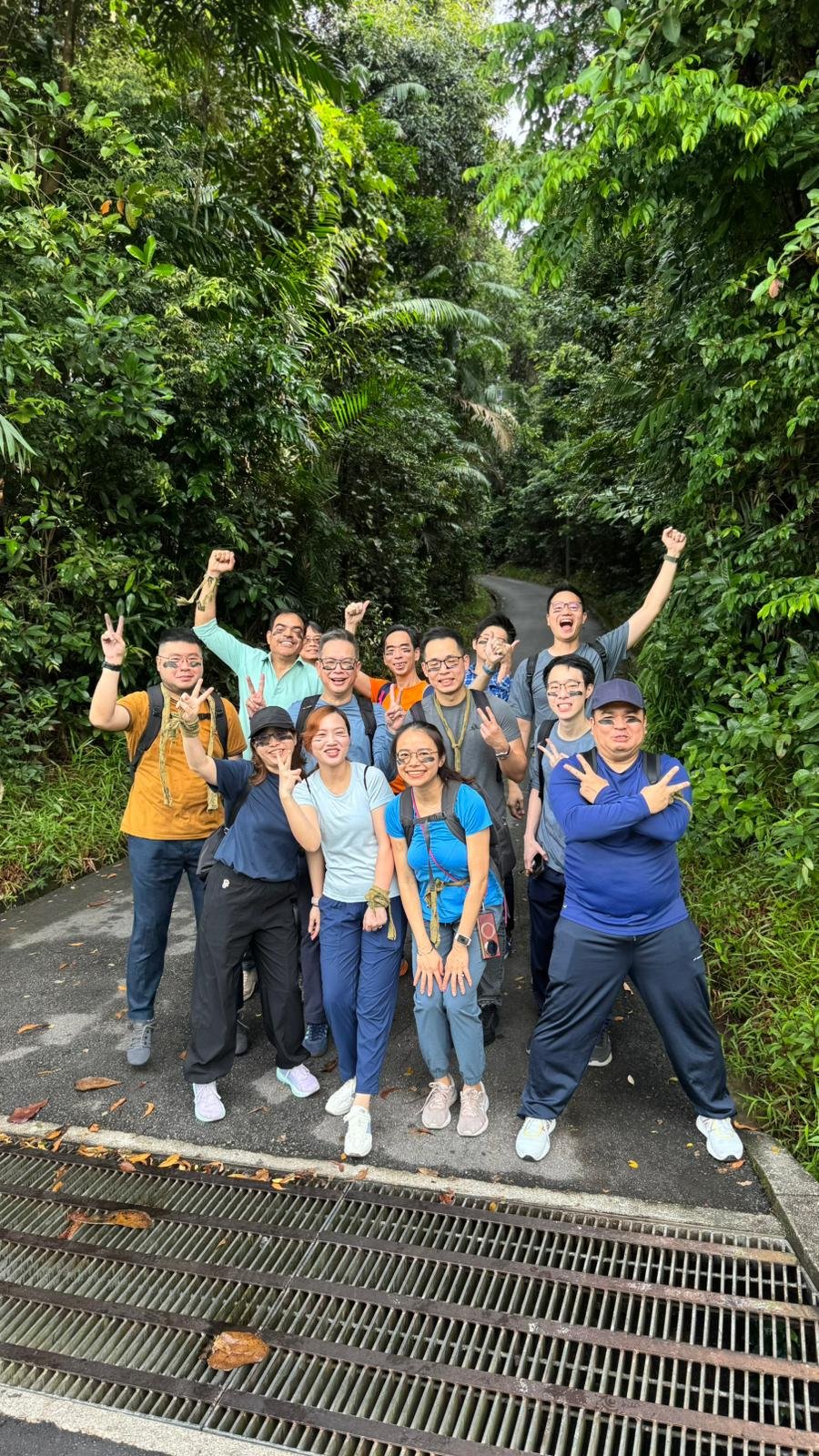 GIC team members cheering and posing together in the jungle at Fort Serapong