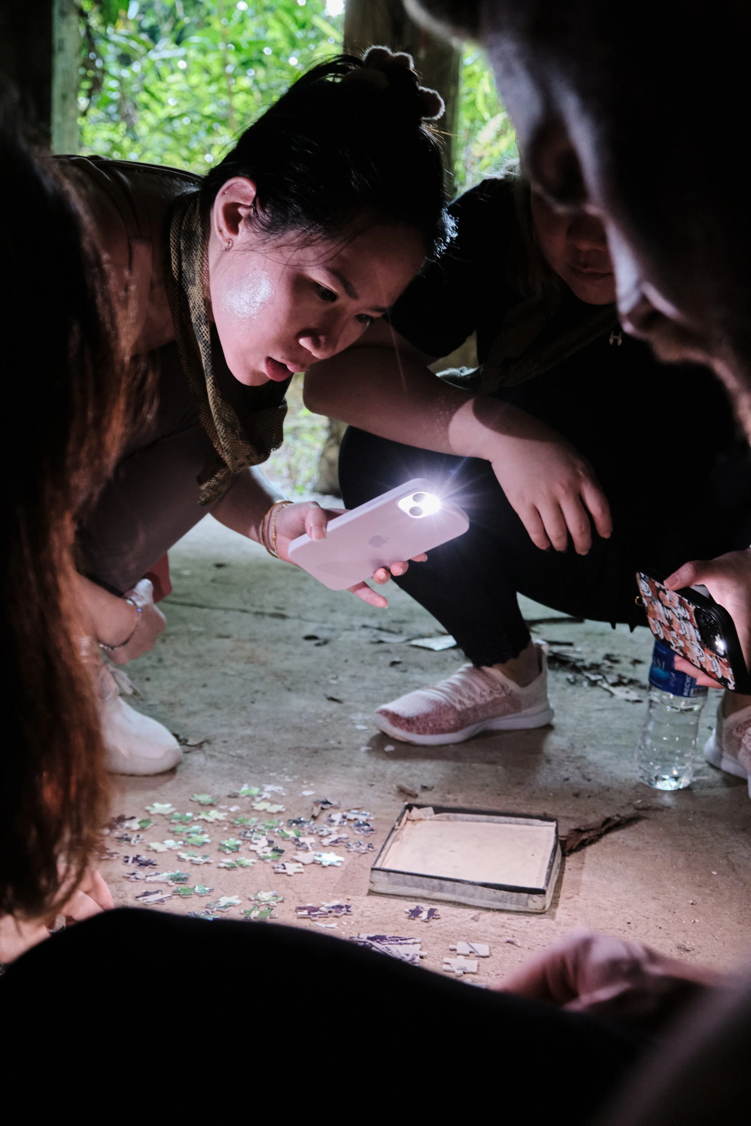 NORDEN team examining heritage clues by flashlight during a Fort Serapong field mission in Singapore