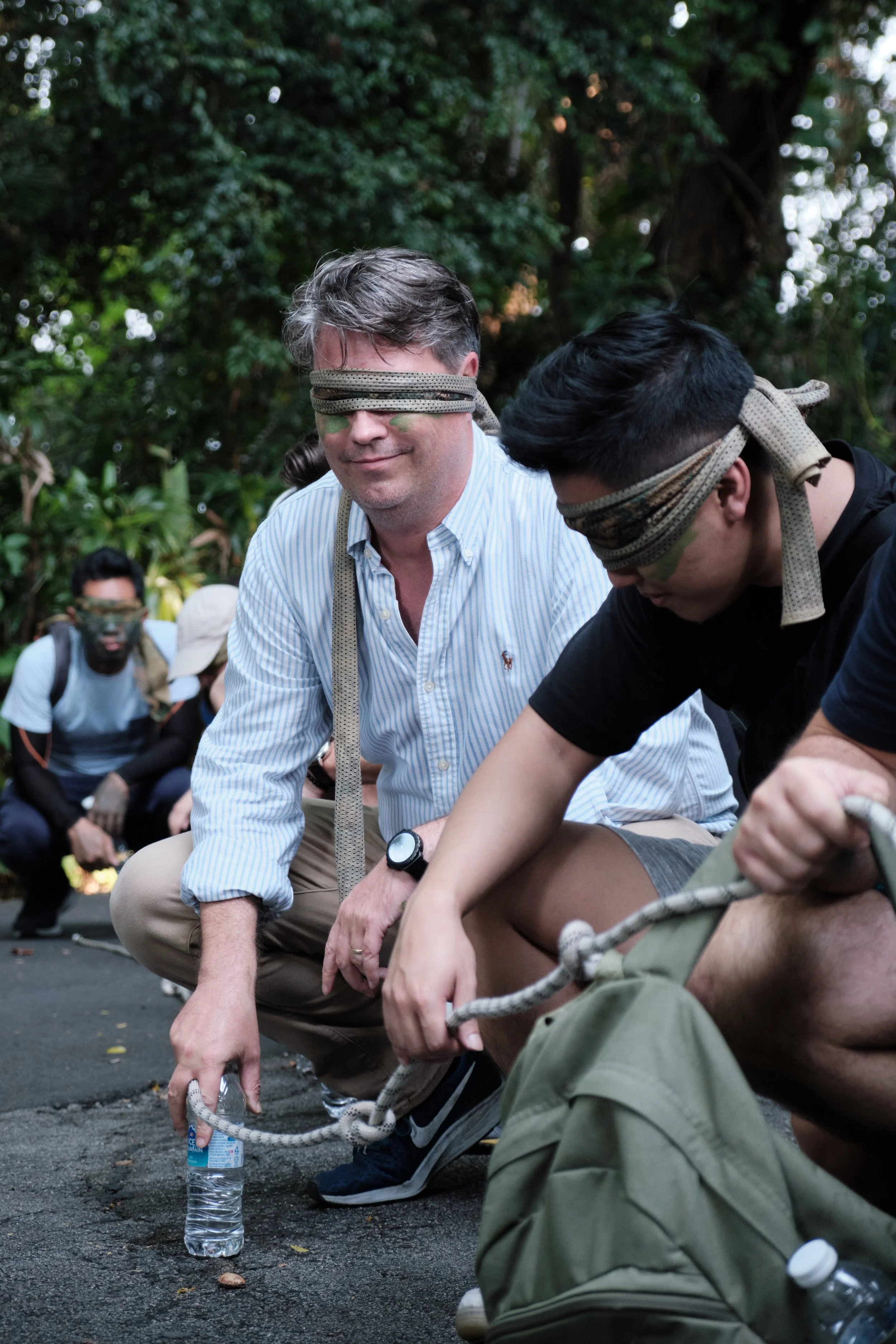 Team member with heritage face paint laughing during an outdoor team bonding mission at Fort Serapong, Singapore