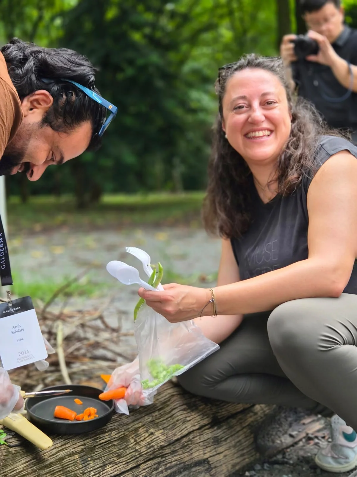 Team member preparing food over an open fire during a hands-on outdoor cooking activity