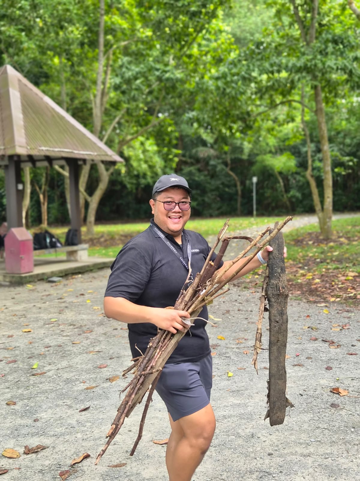 Participant gathering firewood during an outdoor team bonding session in Singapore