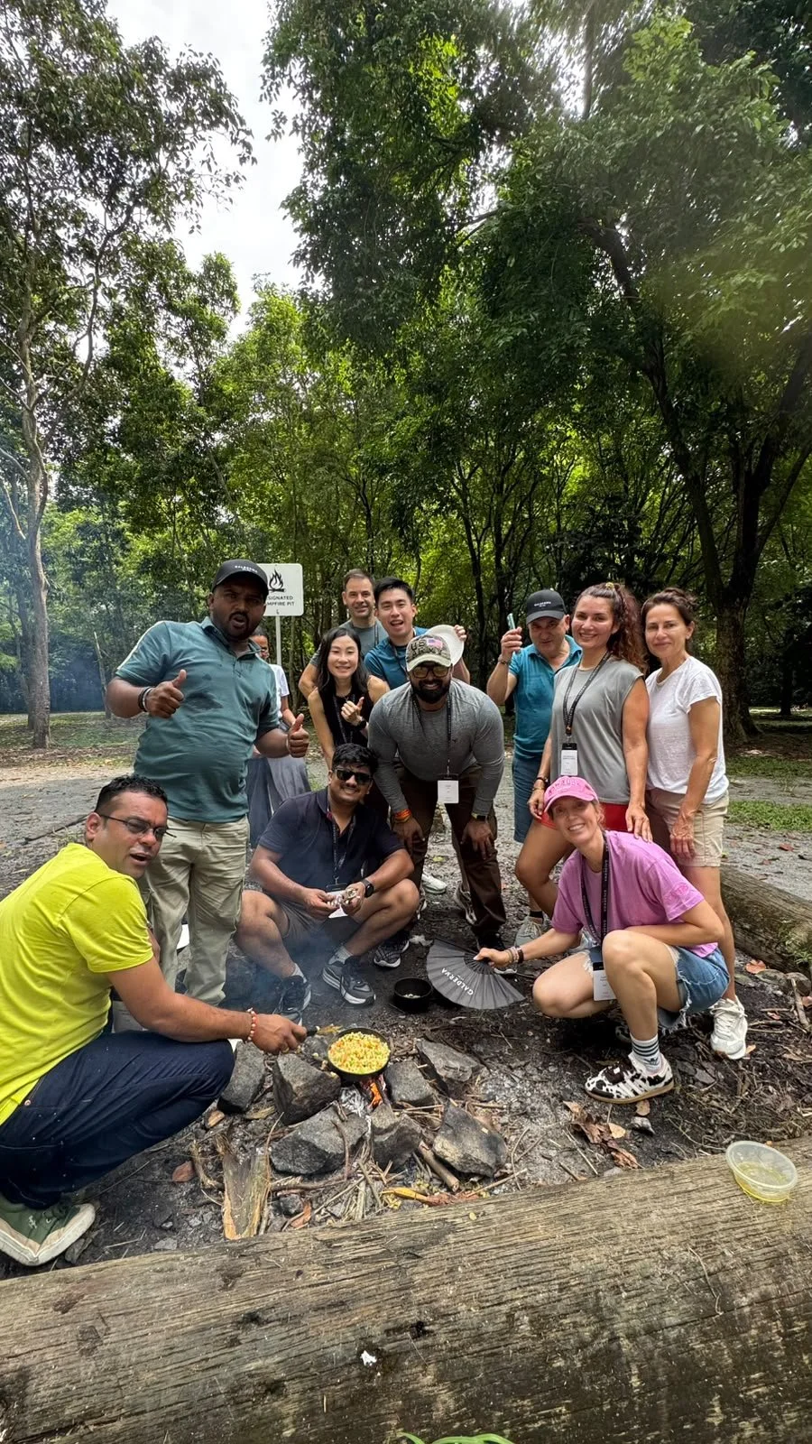 Energetic team posing together during a break in their Singapore outdoor offsite