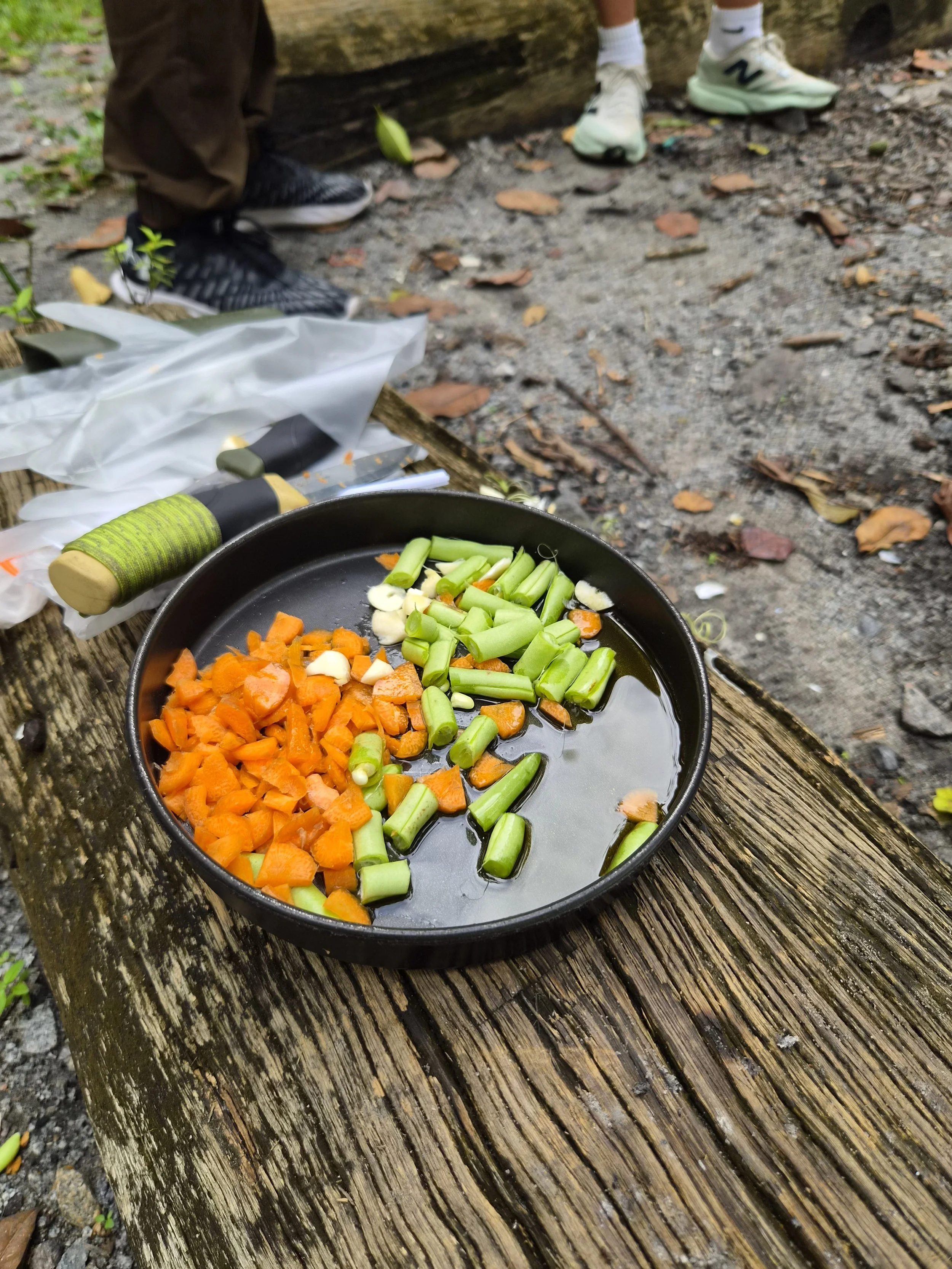 Freshly chopped vegetables in a pan ready for cooking over an open fire