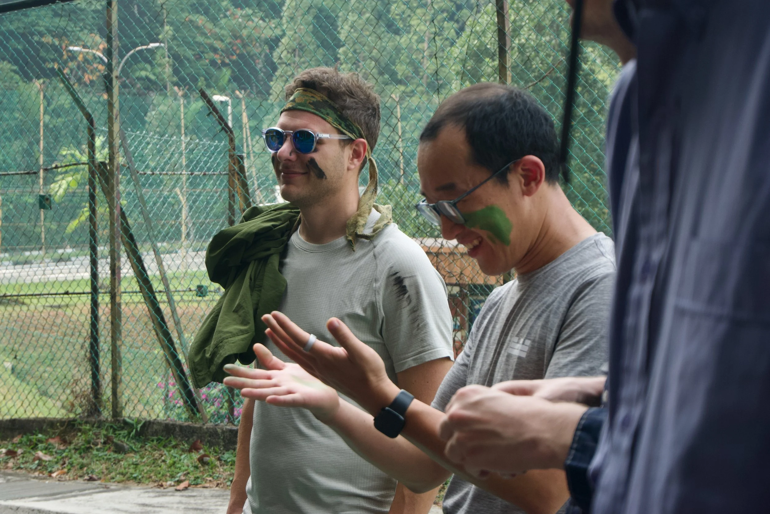 Two Citadel Securities participants with camouflage face paint talking before the mission