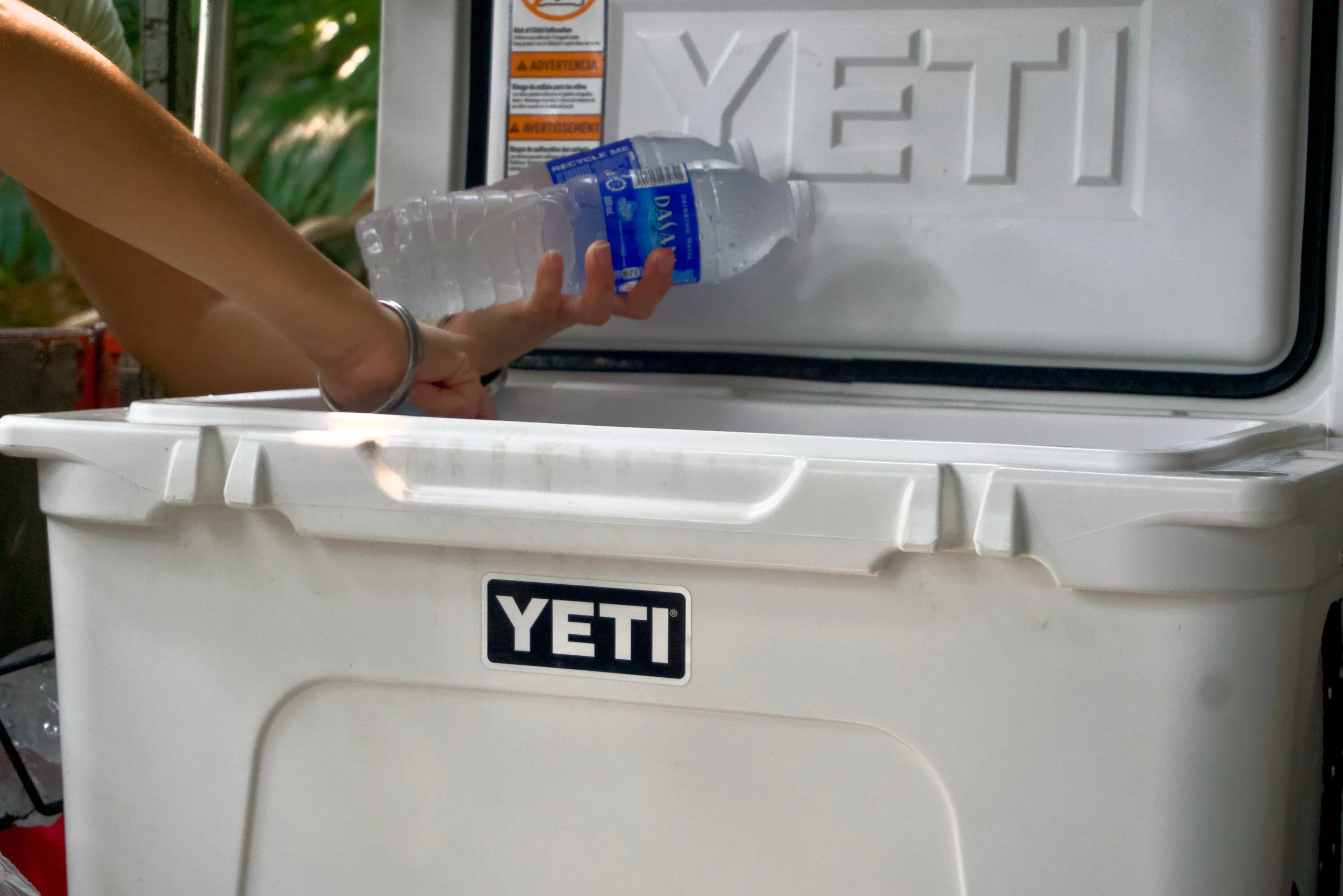 Participant taking a bottle of water from a cooler during the rest stop at Spur Battery, Fort Serapong.