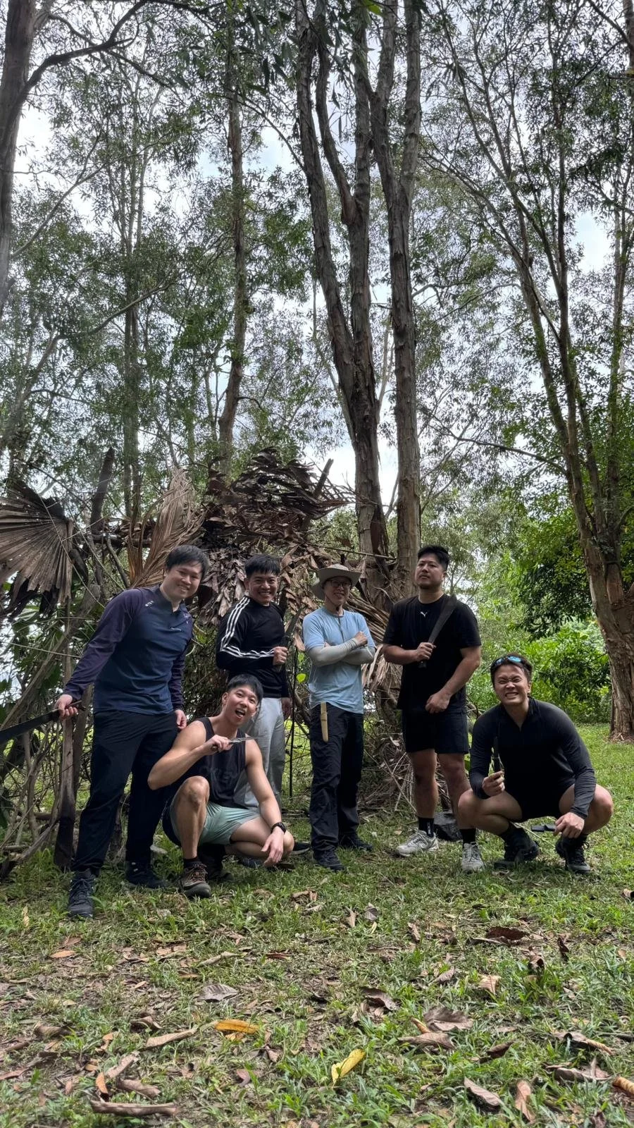 A group of friends standing beneath tall trees in the forest at Pulau Ubin