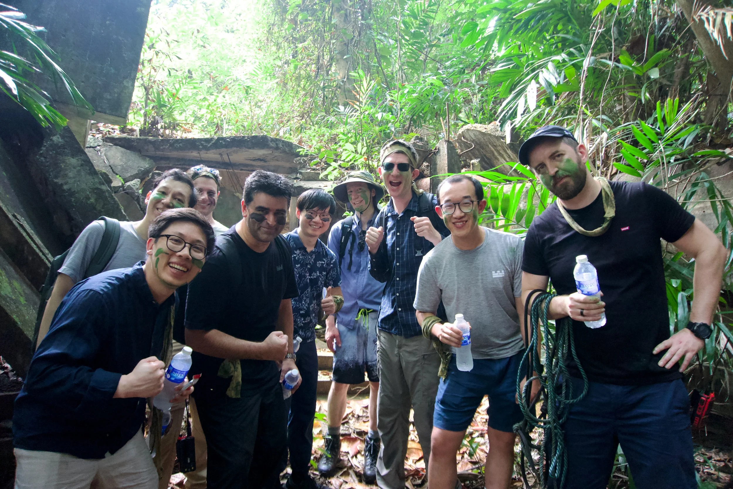 Citadel Securities participants gathered together with water bottles and rope beside a Fort Serapong structure at the end of the mission.
