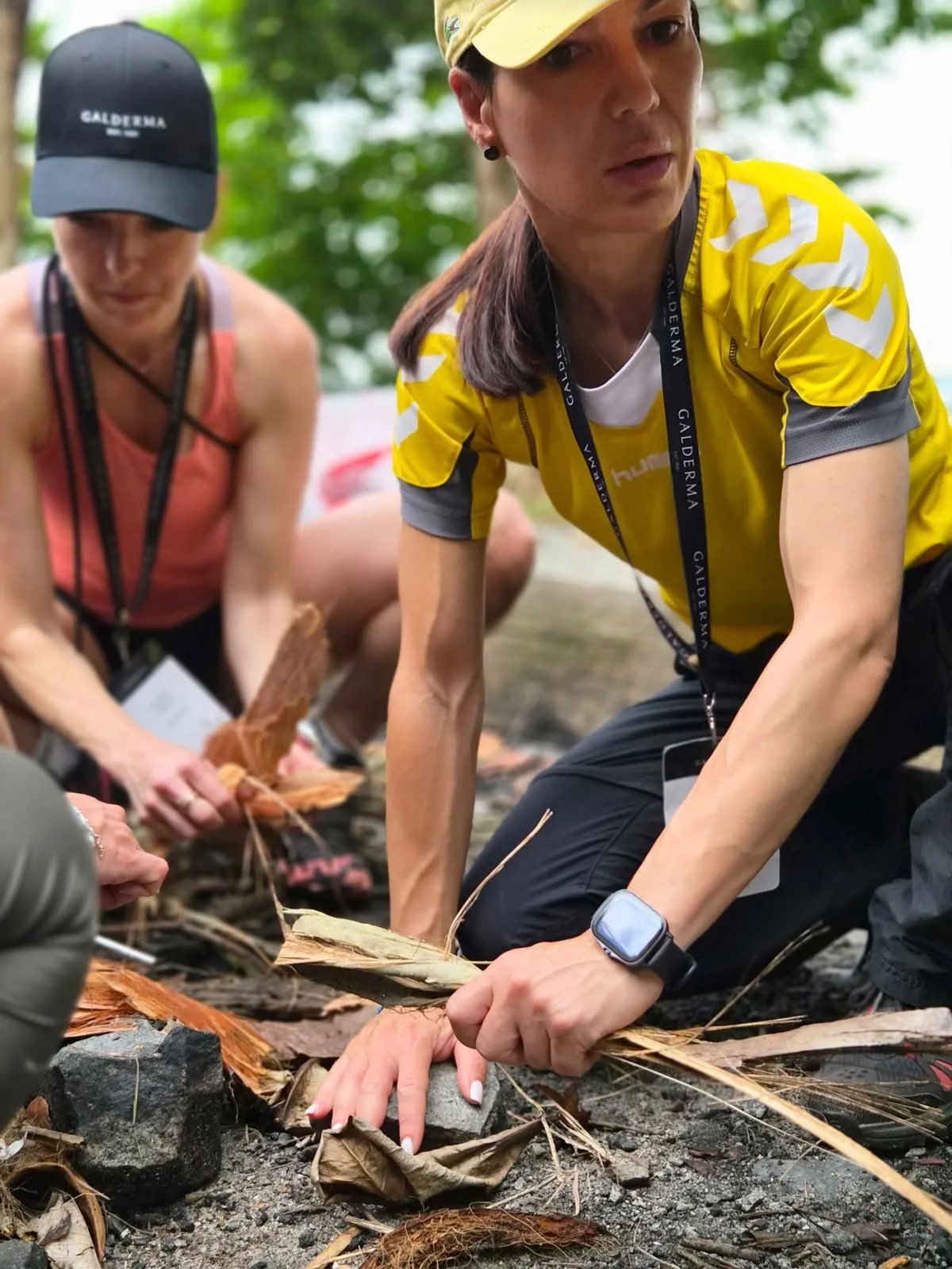 Close-up of hands building a fire from natural kindling during a fire-craft activity