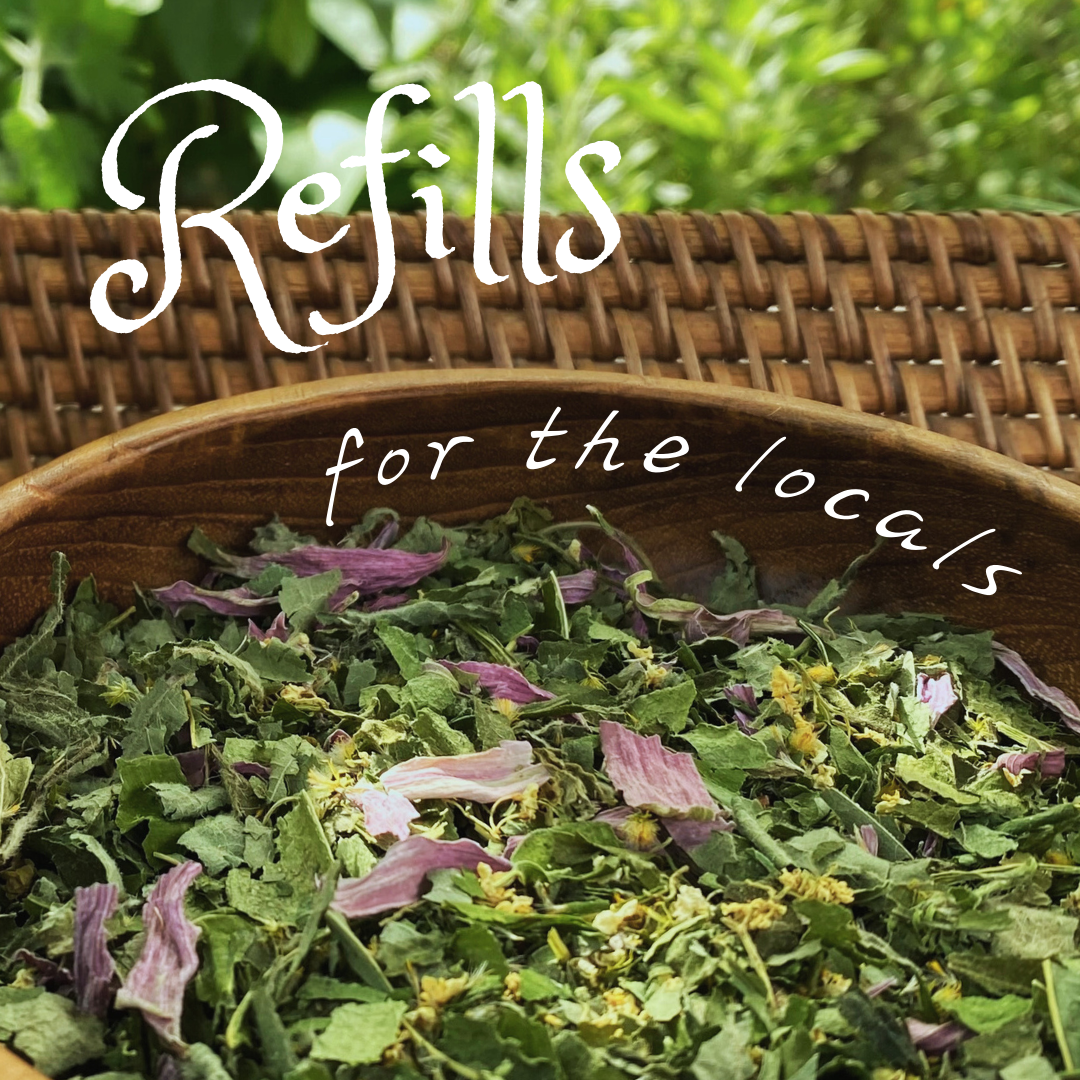 A basket filled with dried herbs or tea leaves, with a blurred green leafy background and text overlay that says "Refils for the locals."