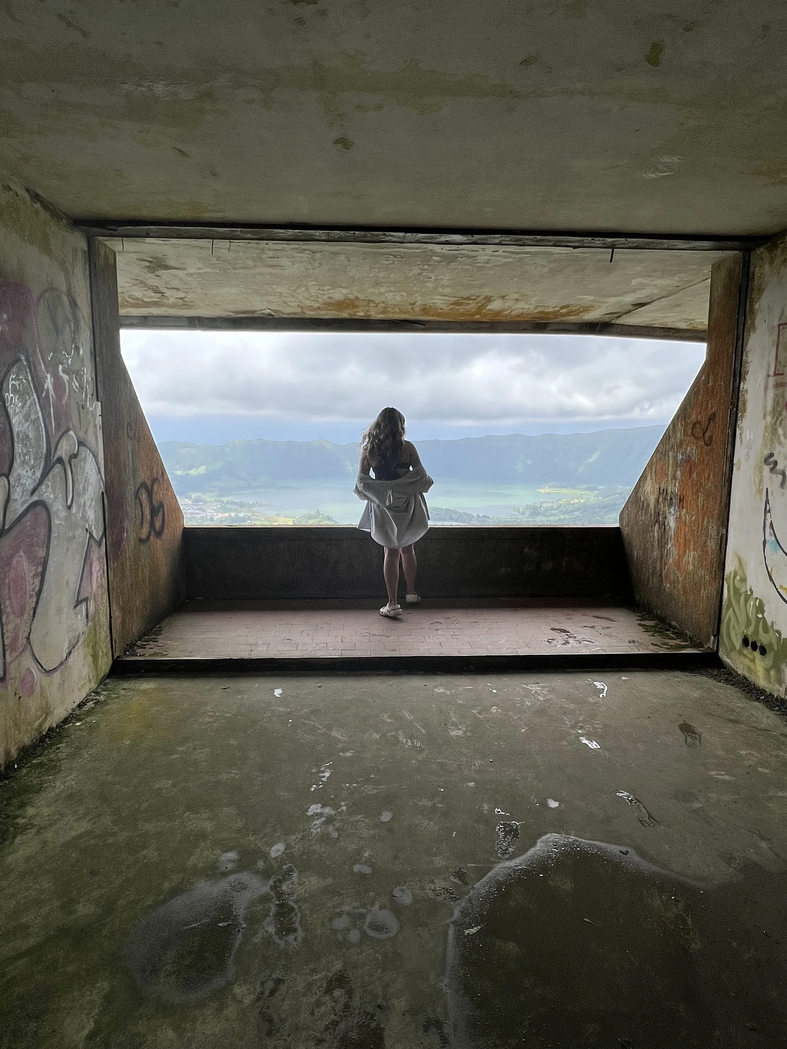 dirty graffiti space with girl in the foreground looking at the distant lake and nature