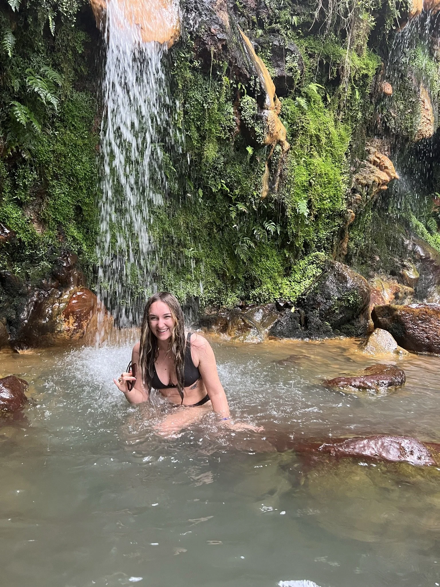 girl having fun under waterfall
