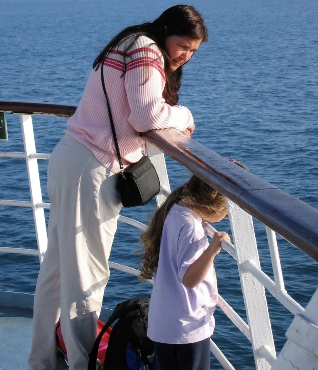 mother and daughter leaning against ship