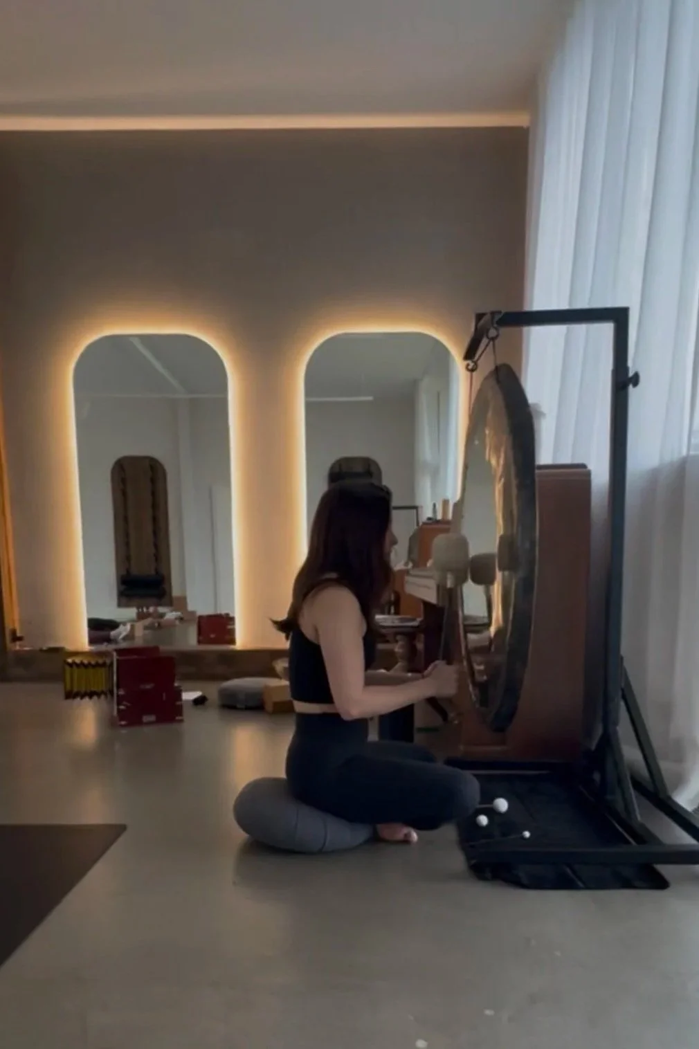 Woman facilitating best gong bath ceremony in Zürich Switzerland
