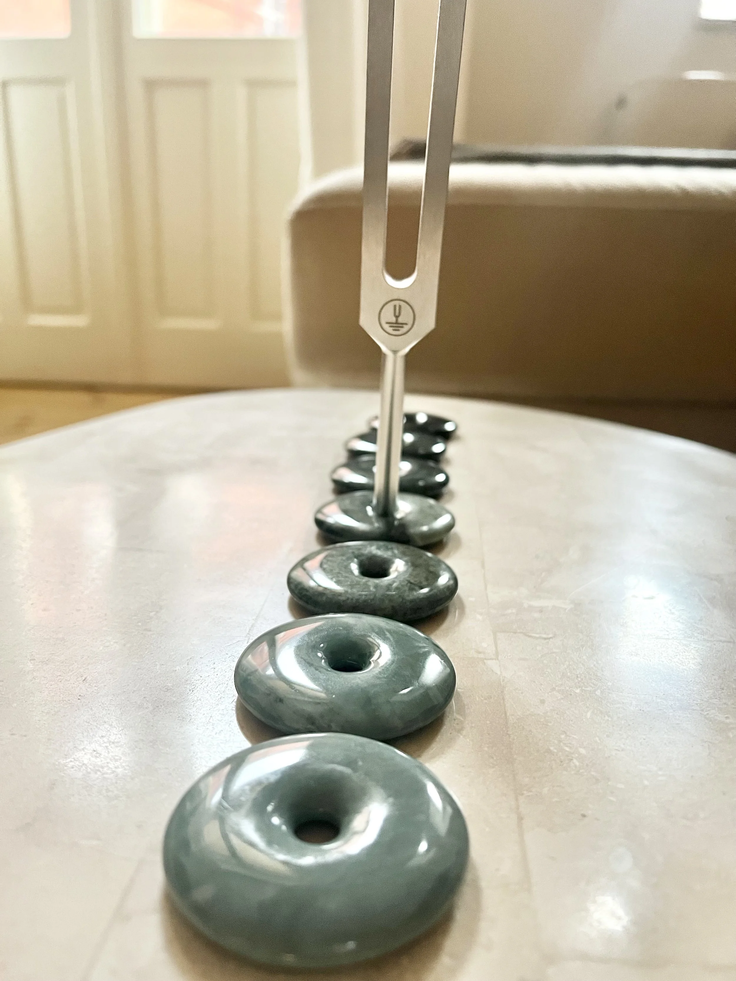 Tuning forks and jade stones used for sound therapy and vibrational healing sessions