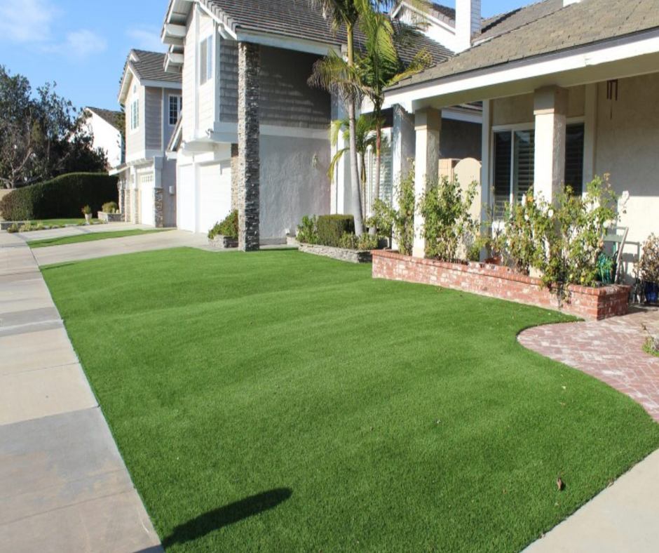 freshly installed artificial turf across the entire lawn, accented by a curved brick path and planter in front of a suburban home