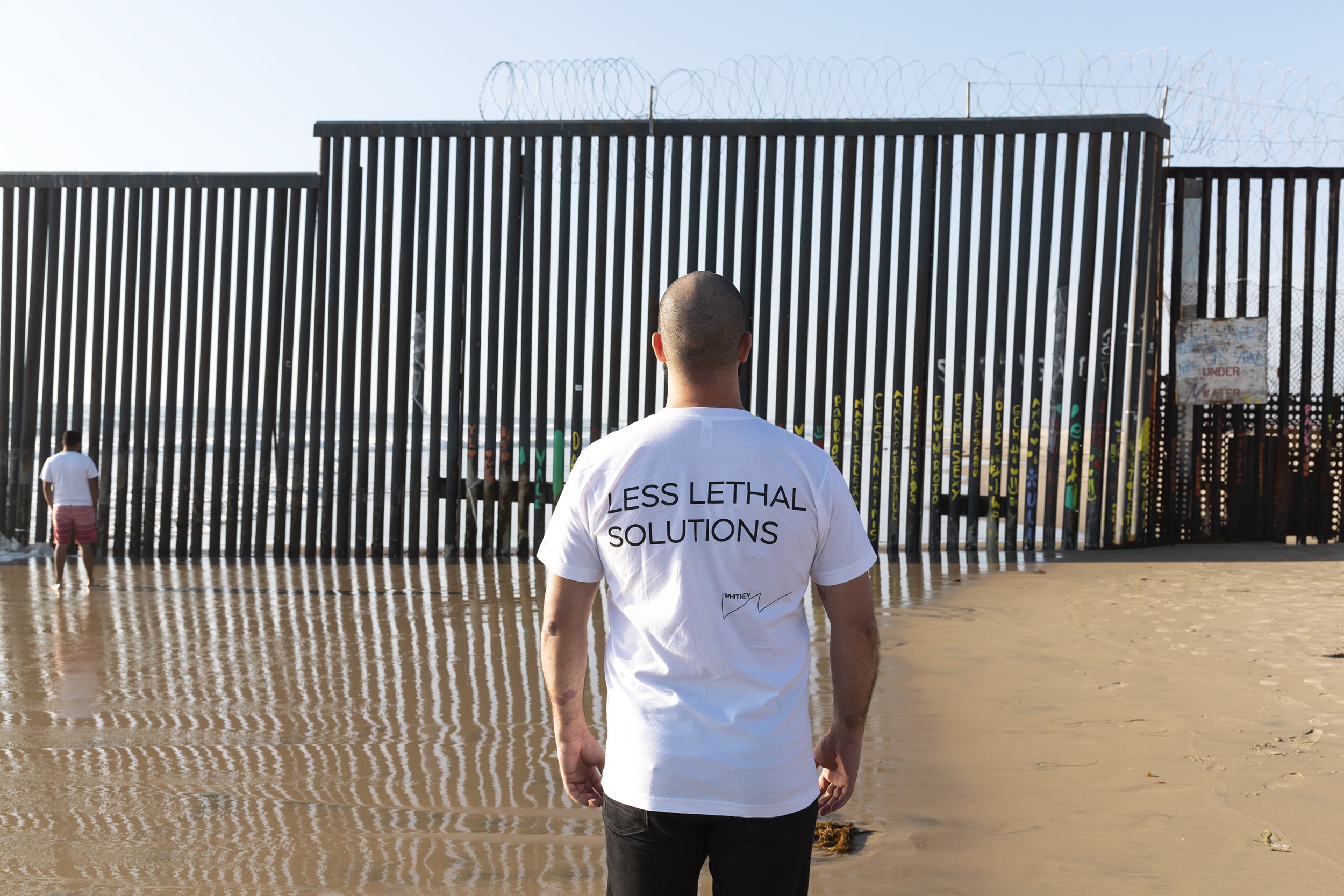   Less Lethal Solutions (US/Mexico Border, Tijuana, MX)  site-specific action, custom silkscreened t-shirt, photographic documentation 