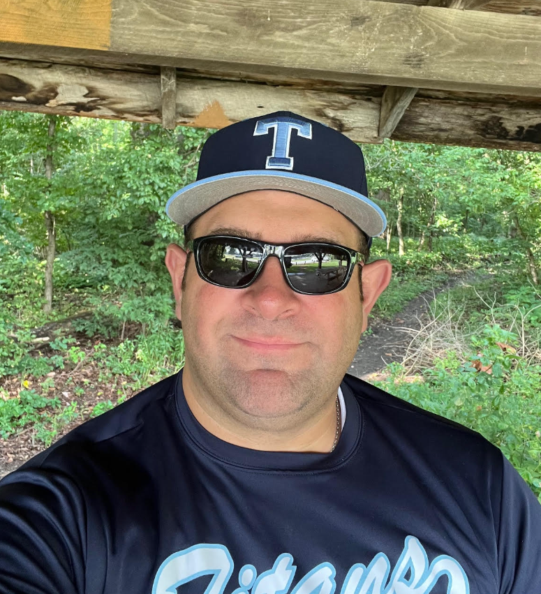 A selfie of Dr. Drew, he is wearing a blue baseball hat, sunglasses, and smiling