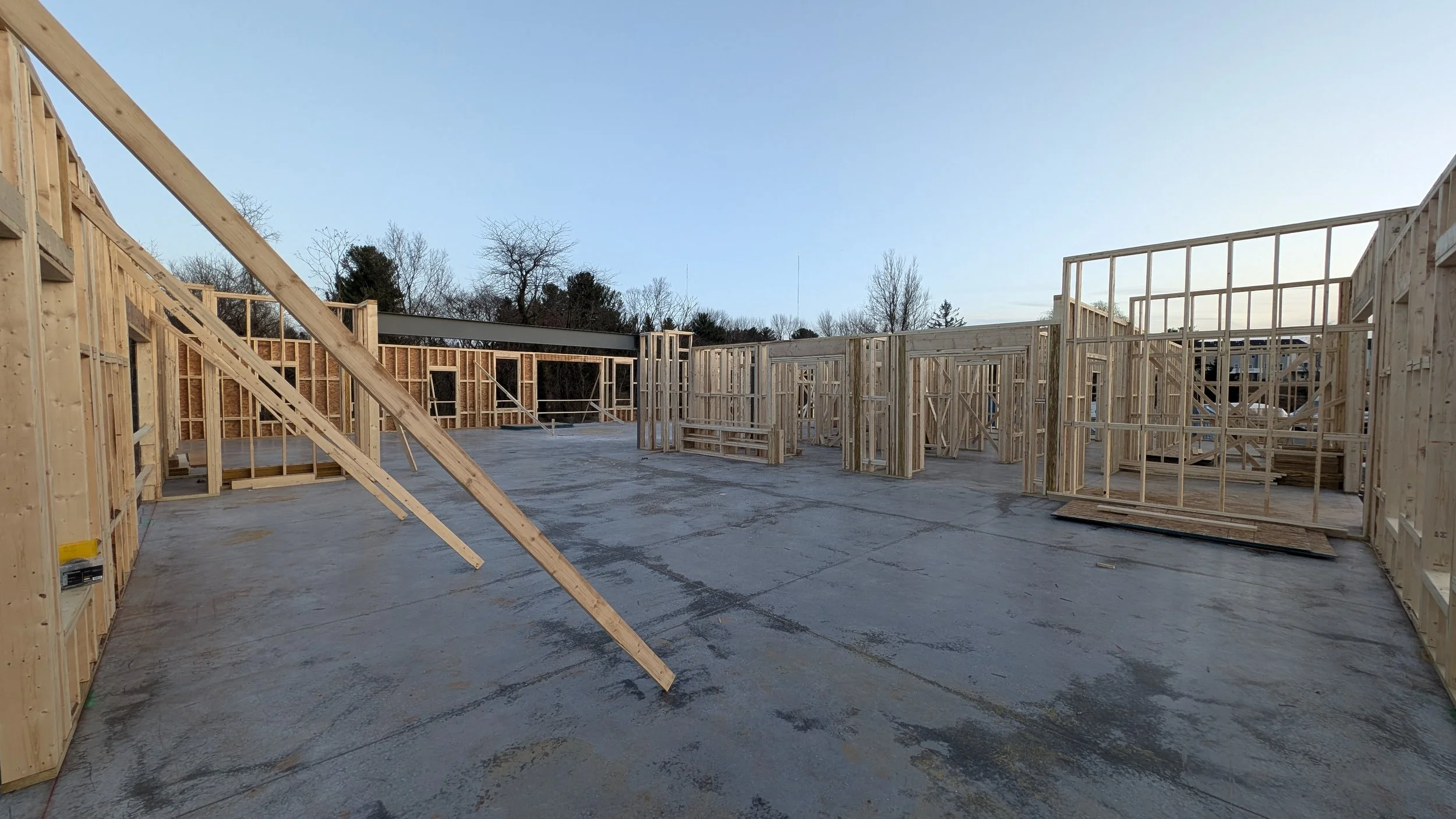 Construction site with wooden framing for a building, and a concrete floor.