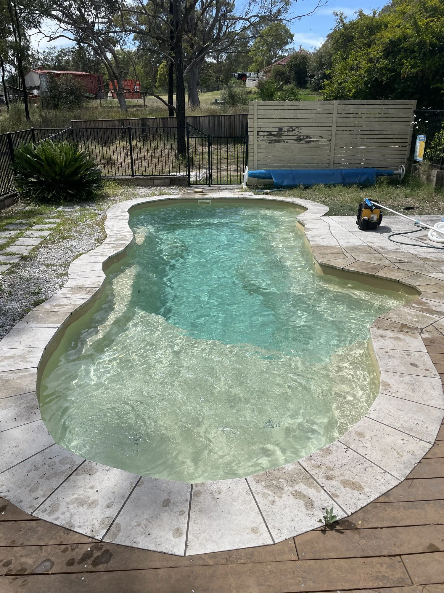 a clean pool in front of a black metal fence
