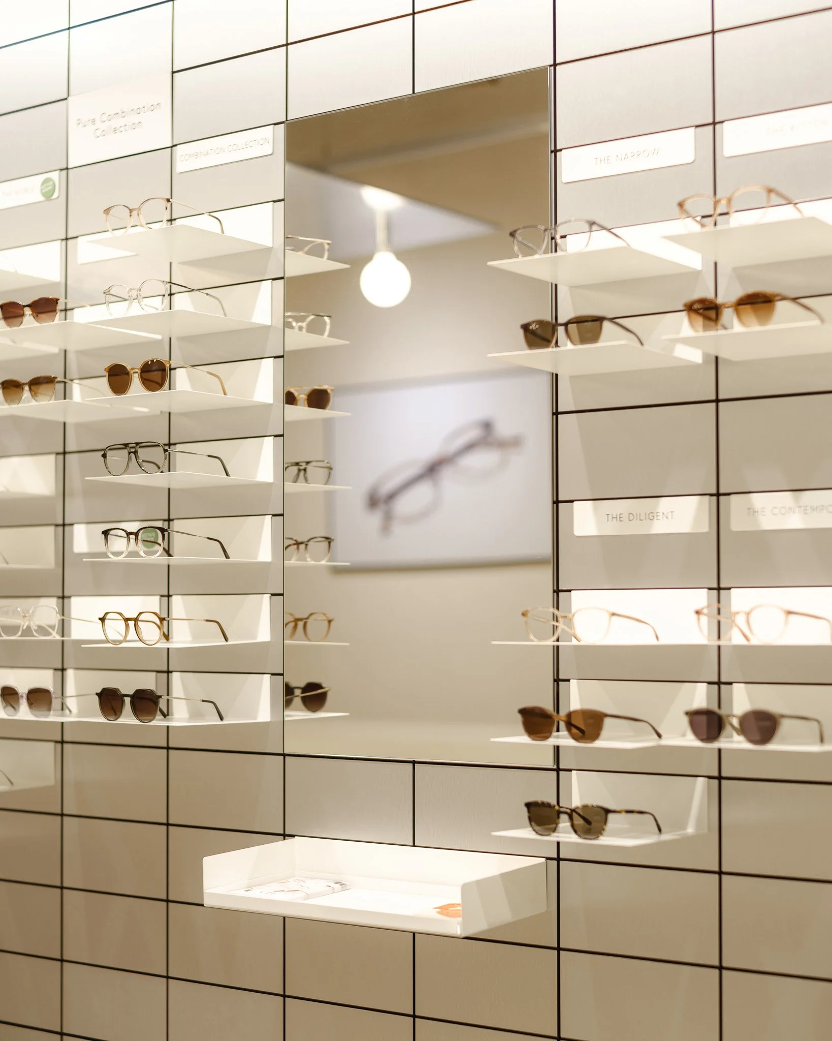 Détail du mur de présentation de lunettes avec miroir, boutique Viu, Bâle; Detail of the eyewear display wall with mirror, Viu store, Basel; Detailansicht der Brillenwand mit Spiegel, Viu-Geschäft in Basel