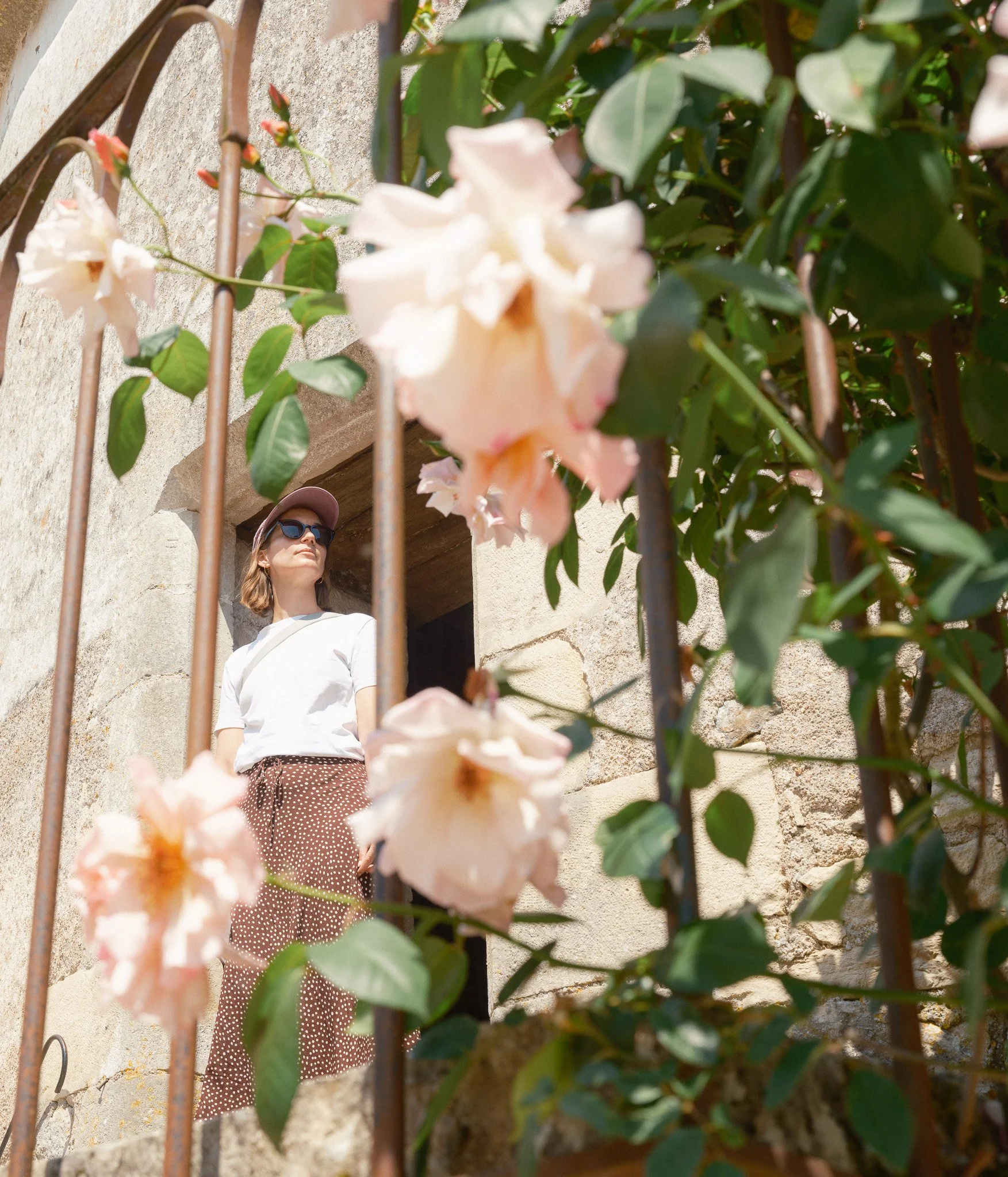 Portrait photographique d'une femme au milieu d'un monument ancien et de fleurs. Porträtfotografie einer Frau inmitten eines antiken Denkmals und Blumen.
