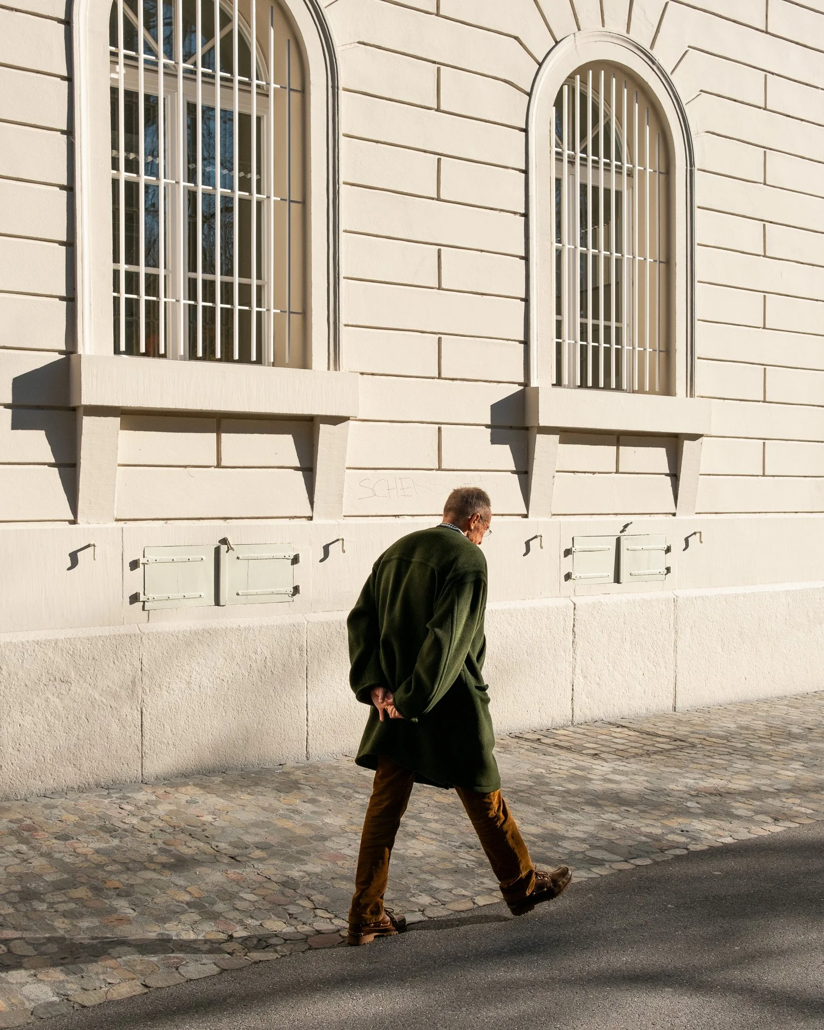 Photographie de rue, un homme marchant dans les rues de Bâle en Suisse. Fotografie einer Straßenszene, ein Mann, der durch die Straßen von Basel in der Schweiz geht.
