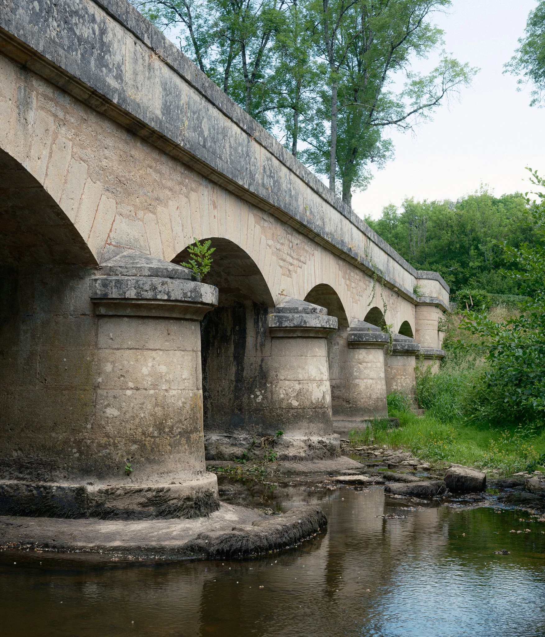Photographie par Antoine Georgelin, un pont en pierre traversant une rivière en Bourgogne, France.
Fotografie von Antoine Georgelin, eine steinerne Brücke, die einen Fluss in Burgund, Frankreich, überquert.