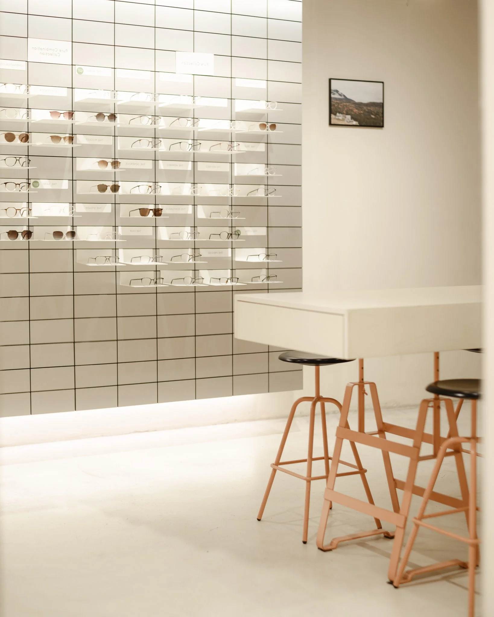 Présentoir de lunettes et coin salon dans la boutique Viu à Bâle; Eyewear display wall and seating area at Viu store, Basel; Brillenwand und Sitzecke im Viu-Geschäft in Basel