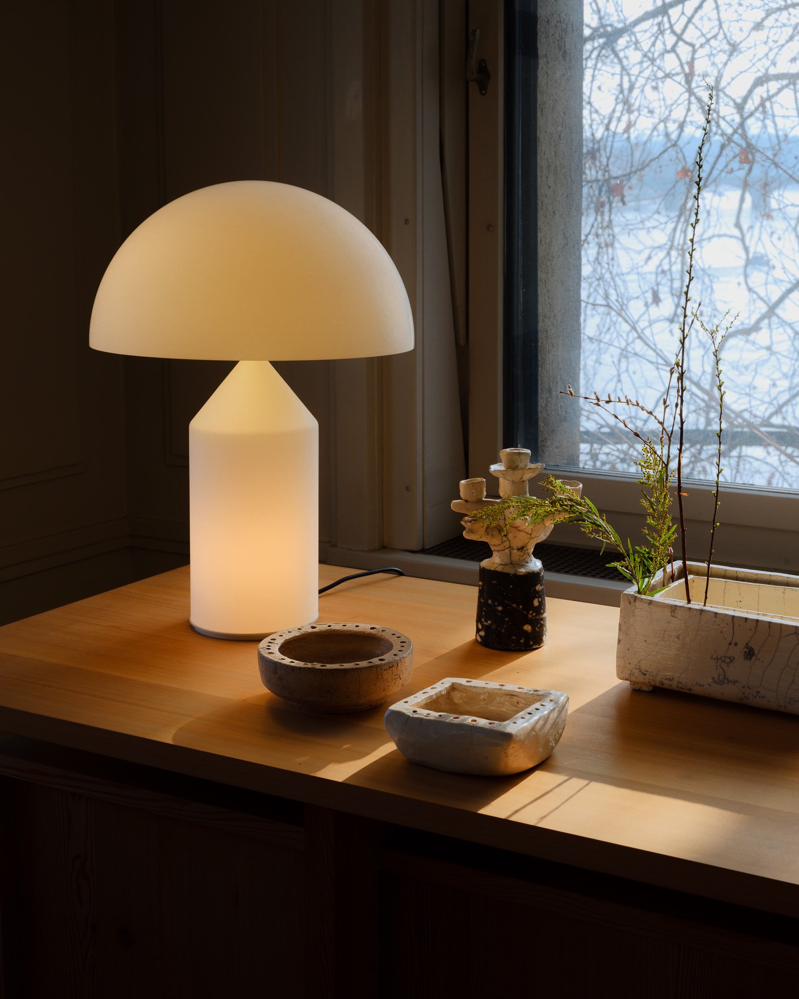 Lampe Atollo et objets en céramique sur une table, boutique Grimsel, Bâle; Atollo lamp and ceramic objects on a table, Grimsel store, Basel; Atollo-Lampe und Keramikobjekte auf einem Tisch, Grimsel-Geschäft in Basel
