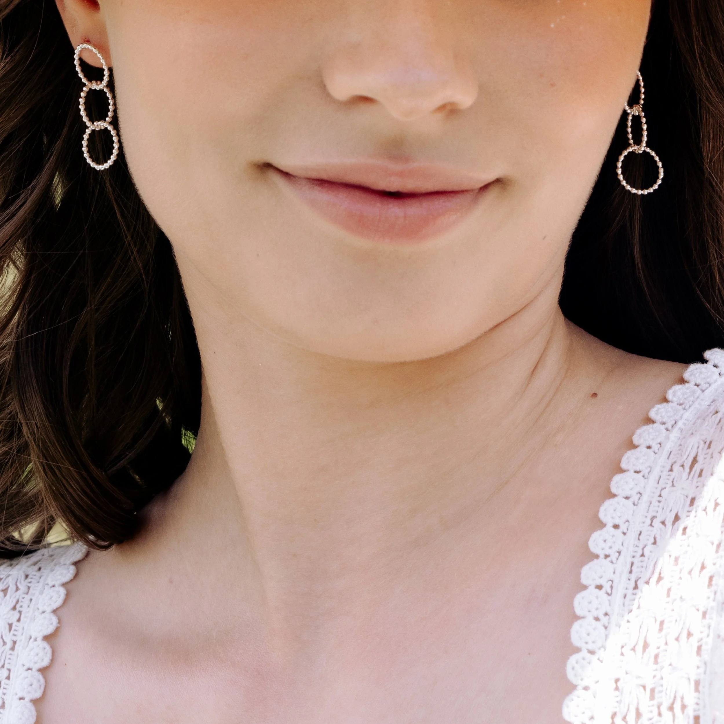 Sterling silver multi-hoop earrings with polished bead accents and textured loops arranged in a layered, contemporary design.