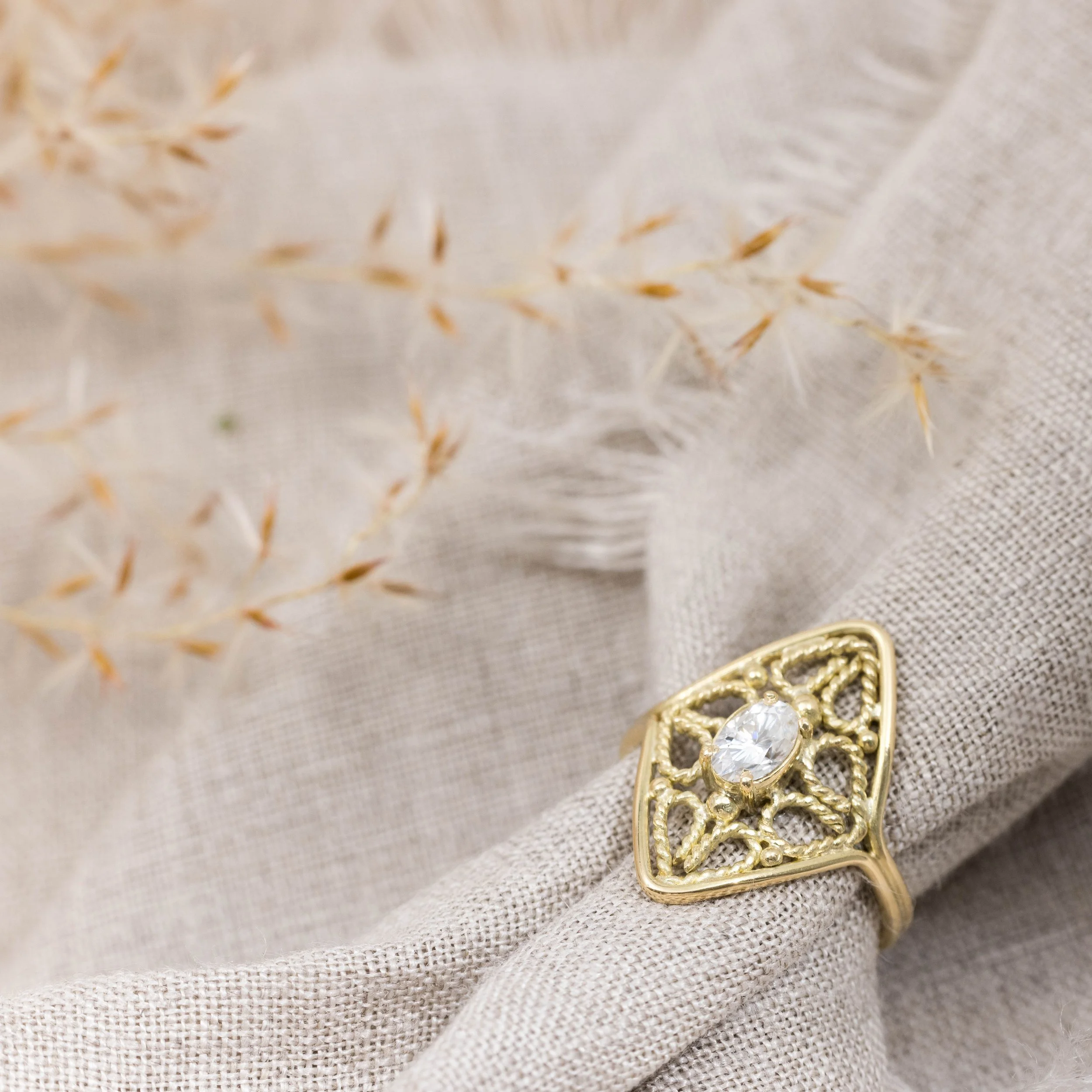 18ct yellow gold filigree ring with oval brilliant-cut moissanite centre stone and intricate vintage-inspired detailing.