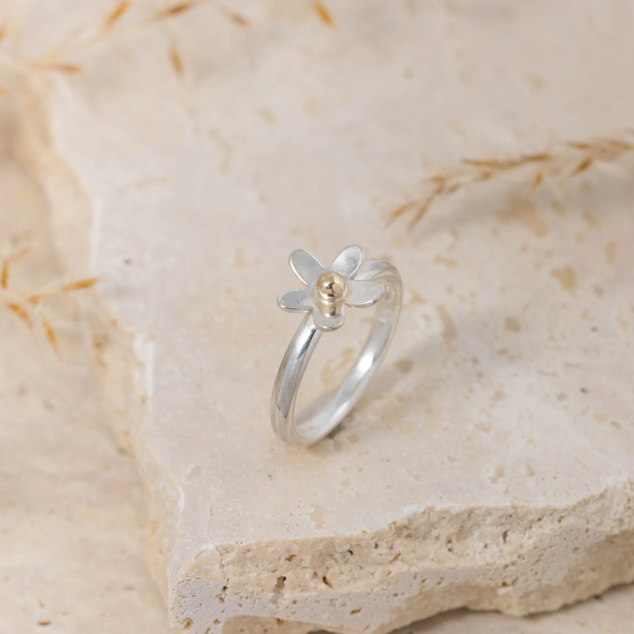 Sterling silver daisy ring with a polished band and detailed medium-sized flower design featuring 9ct gold stamen and a domed centre.