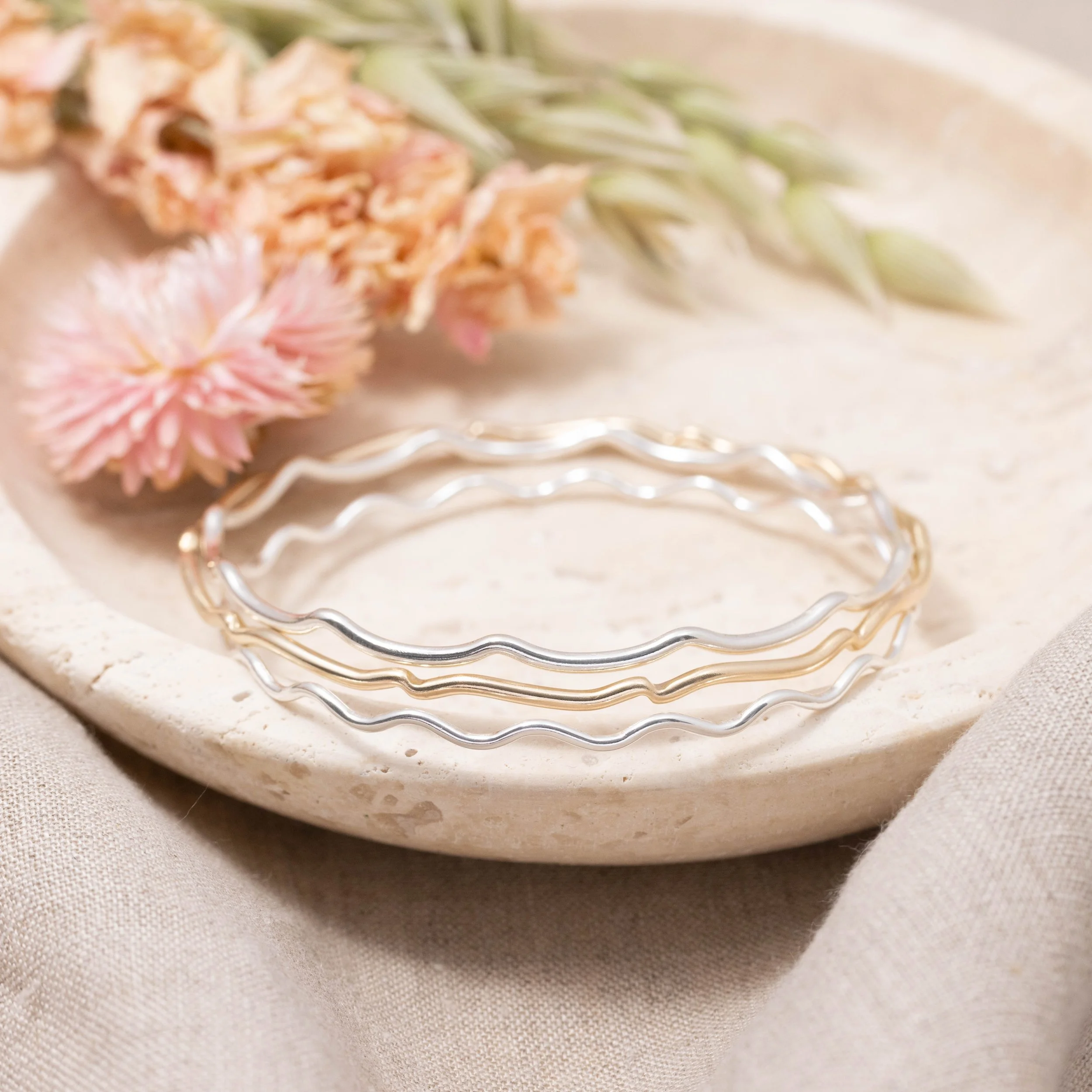 9ct yellow gold scallop bangle with a smooth polished finish and subtle scalloped edge, designed for elegant stacking and everyday wear.