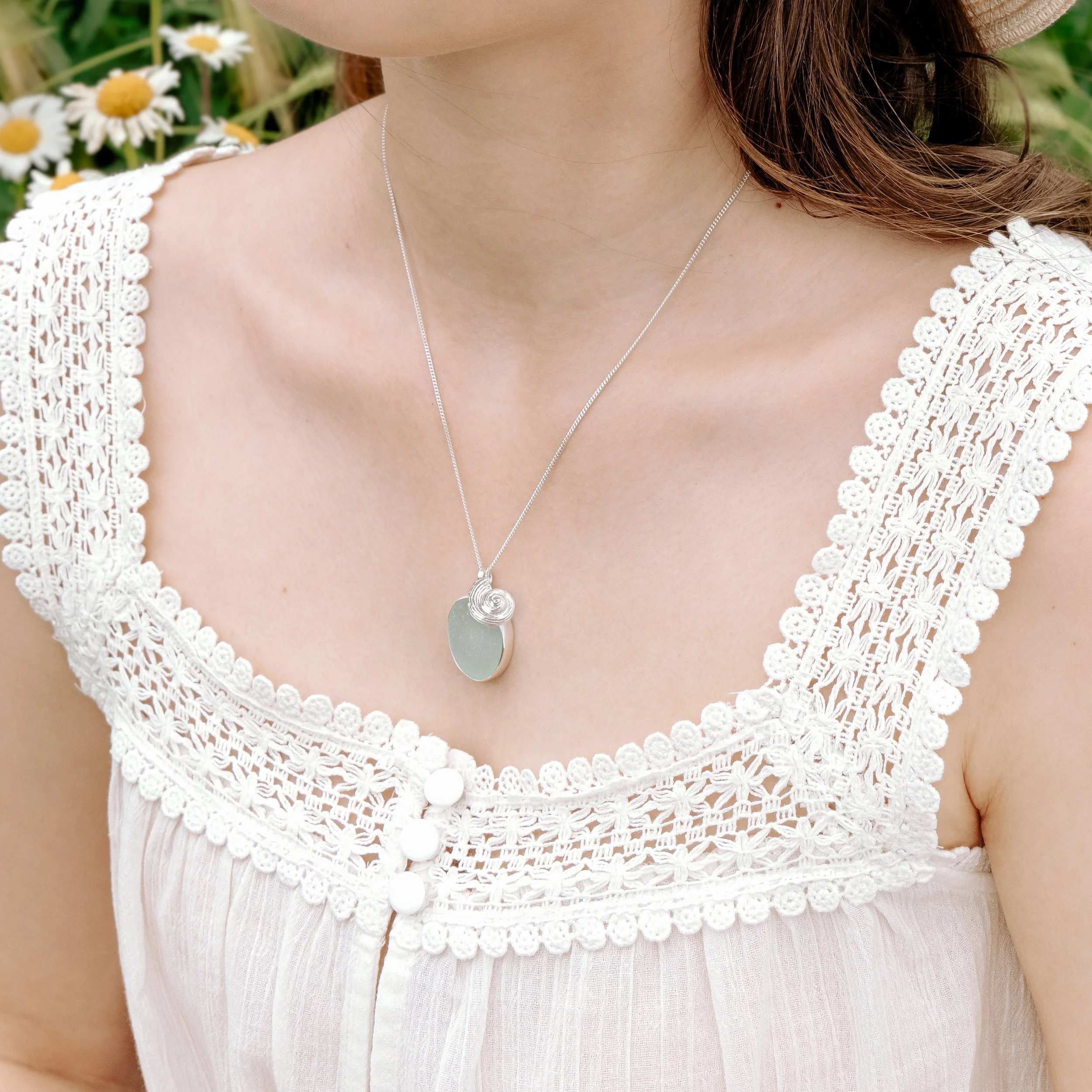 Handmade aquamarine sea glass pebble and sterling silver ammonite pendant cluster on a fine silver chain. Coastal inspired jewellery by Silver Daisy.