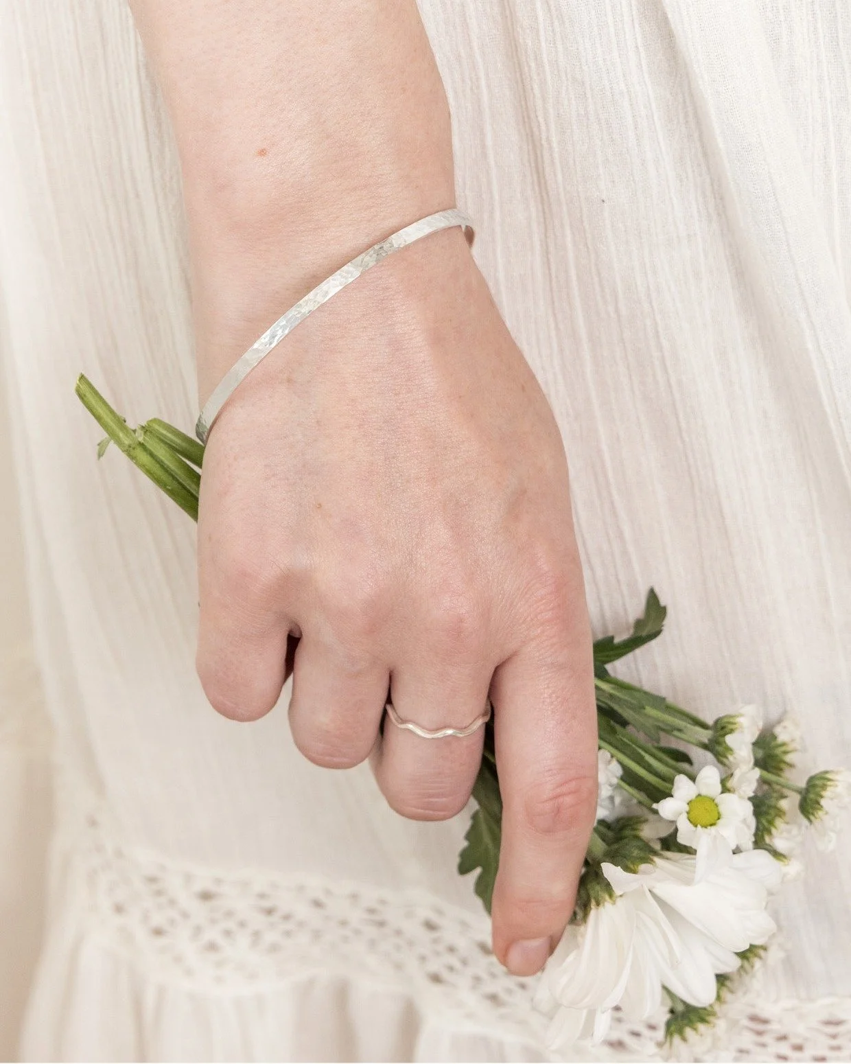 The Silver Dimpled Hammered Bangle

Simple, timeless and made to catch the light beautifully.

Our Silver Dimpled Hammered Bangle is handcrafted in sterling silver, with its gently hammered surface creating a subtle texture that gives each piece its 