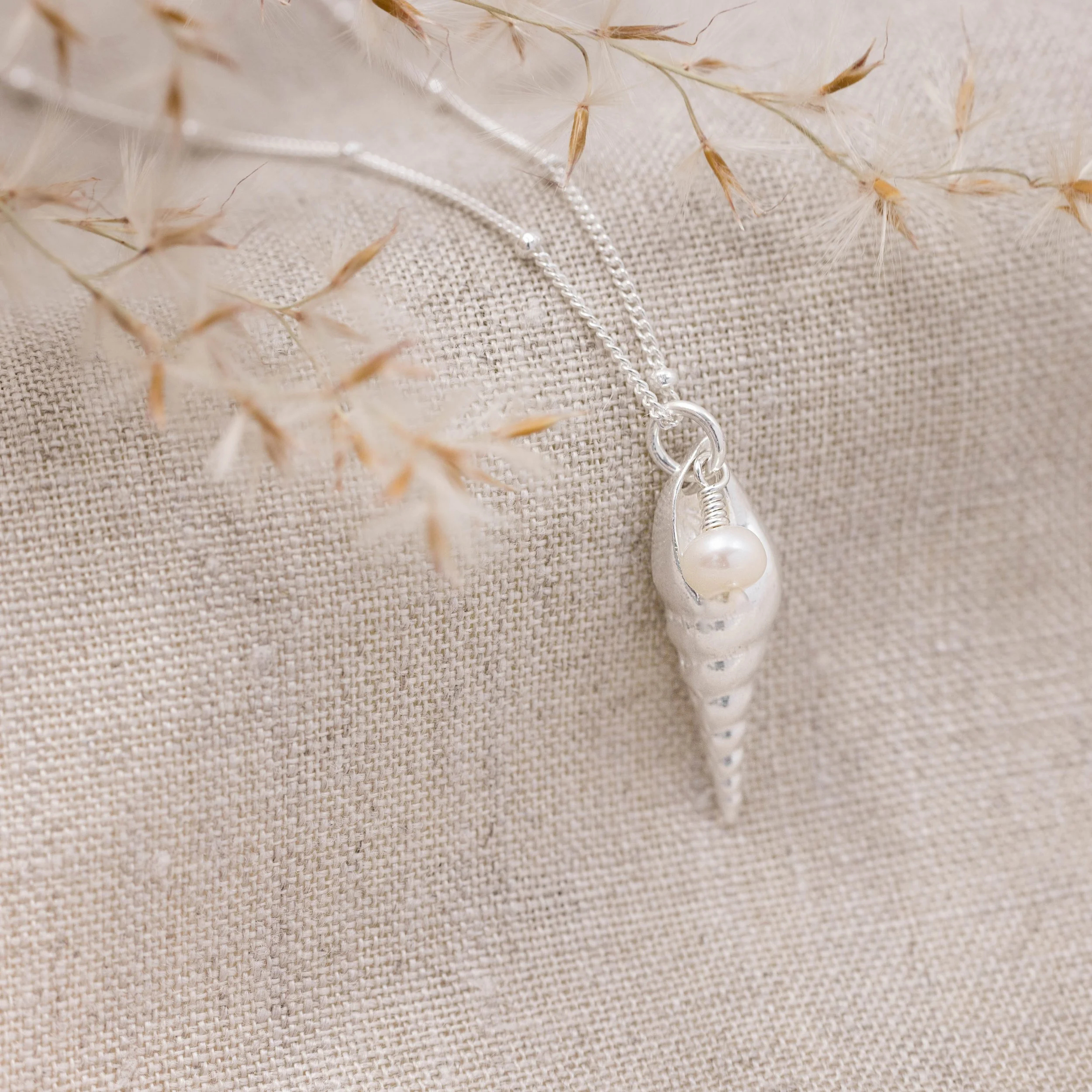 Sterling silver unicorn shell pendant necklace with a single round white pearl on a delicate chain.