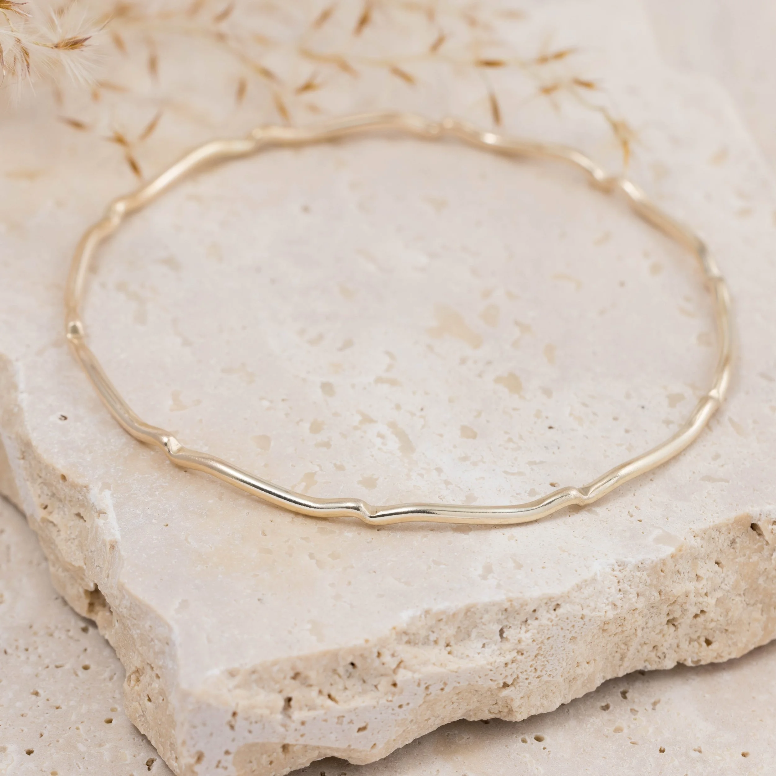 9ct yellow gold scallop bangle with a smooth polished finish and subtle scalloped edge, designed for elegant stacking and everyday wear.