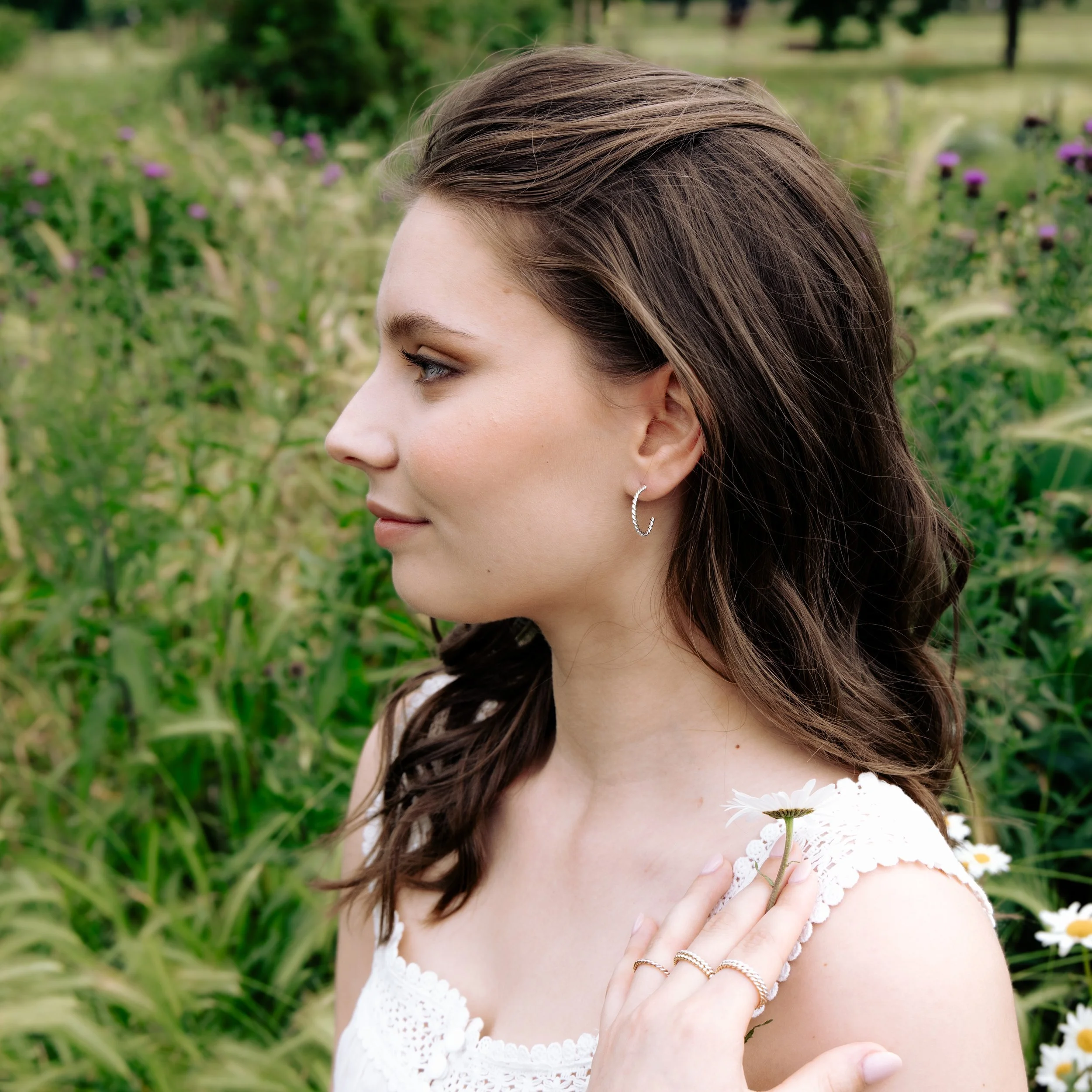 Polished sterling silver twist hoop earrings with a textured spiral design, lightweight and elegant for everyday wear.