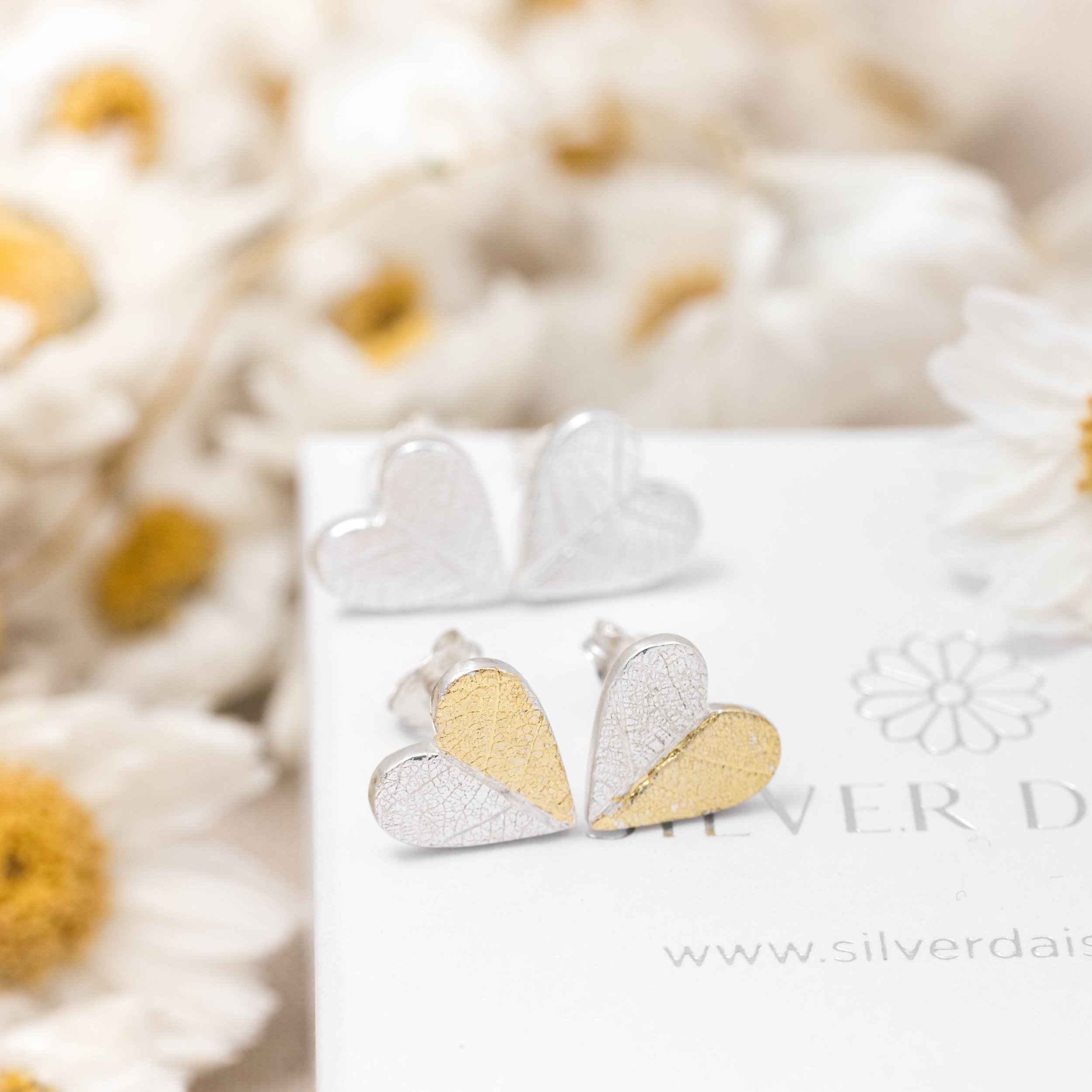 Sterling silver heart-shaped stud earrings with textured leaf pattern and gold keum-boo accents.